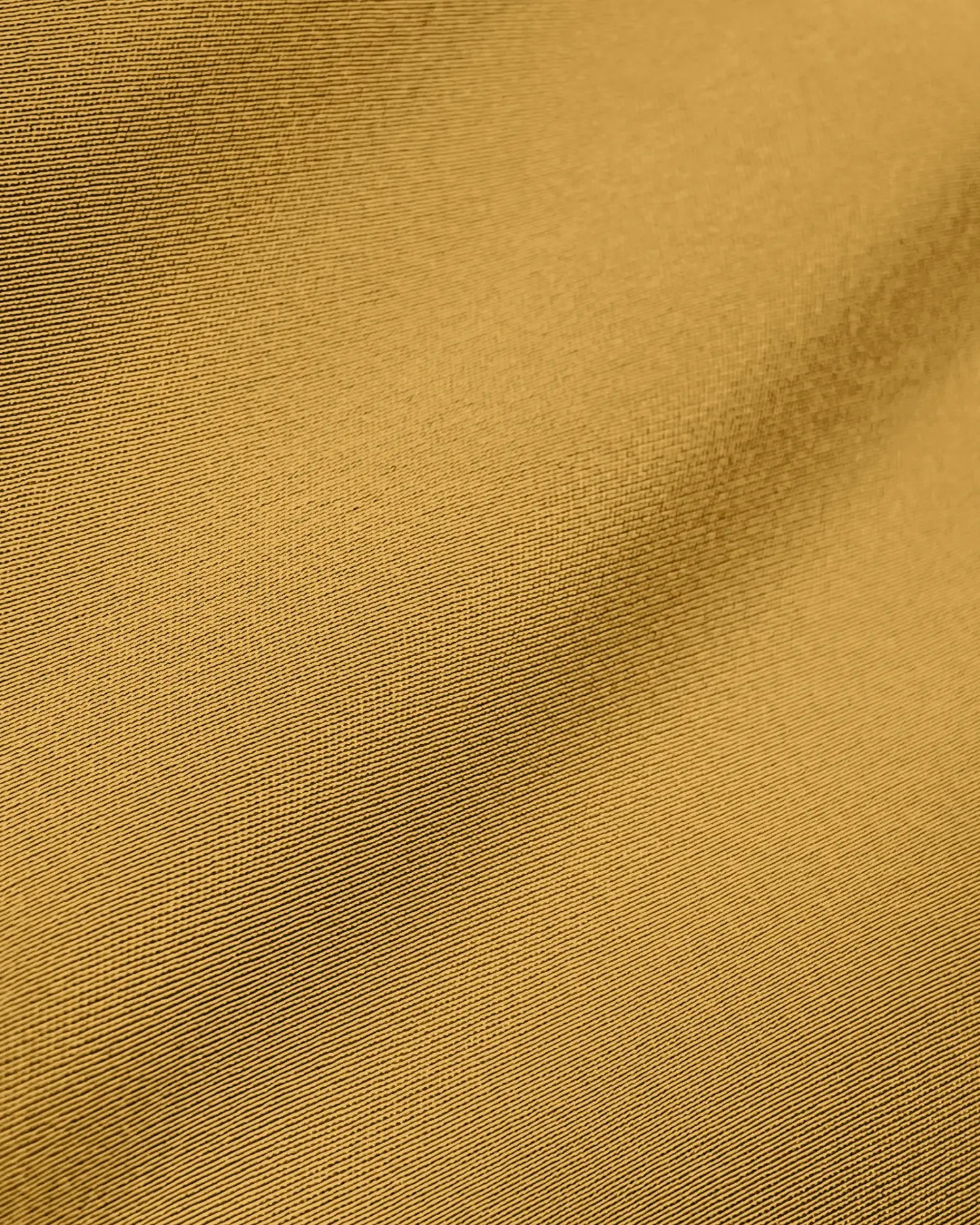 Close-up of smooth mustard yellow fabric texture, highlighting woven pattern and subtle shadows for textile design.
