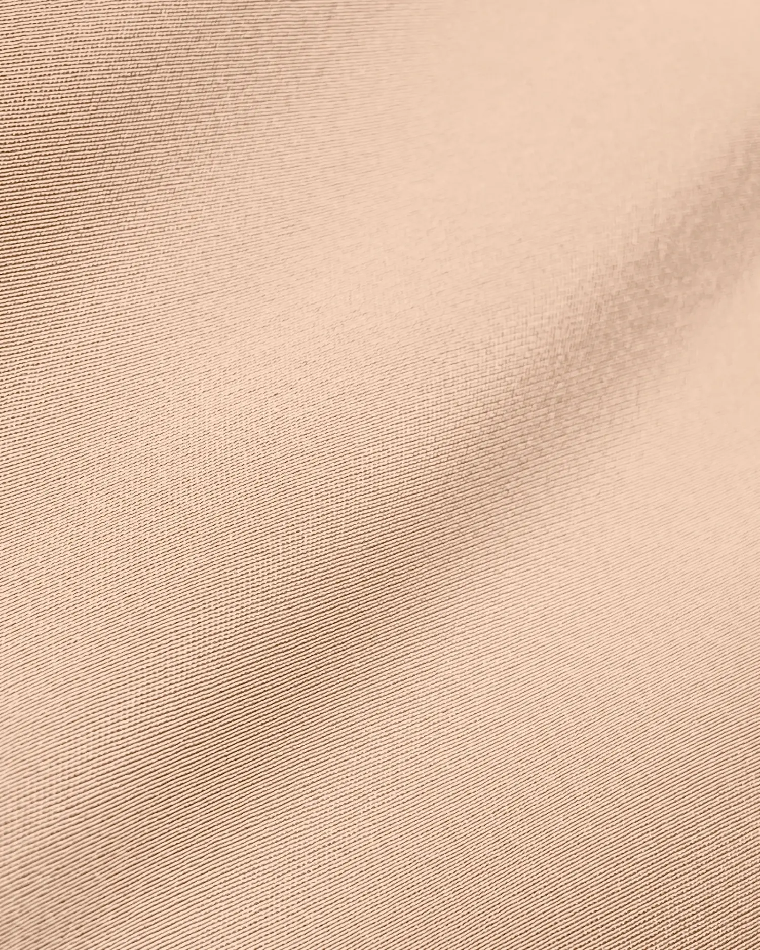 Close-up of beige fabric texture with subtle patterns, ideal for backgrounds or textile design inspiration.