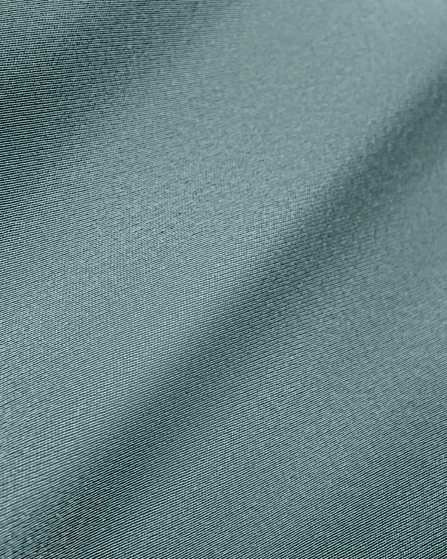 Close-up of smooth, teal fabric texture with subtle lighting and fine detailing.