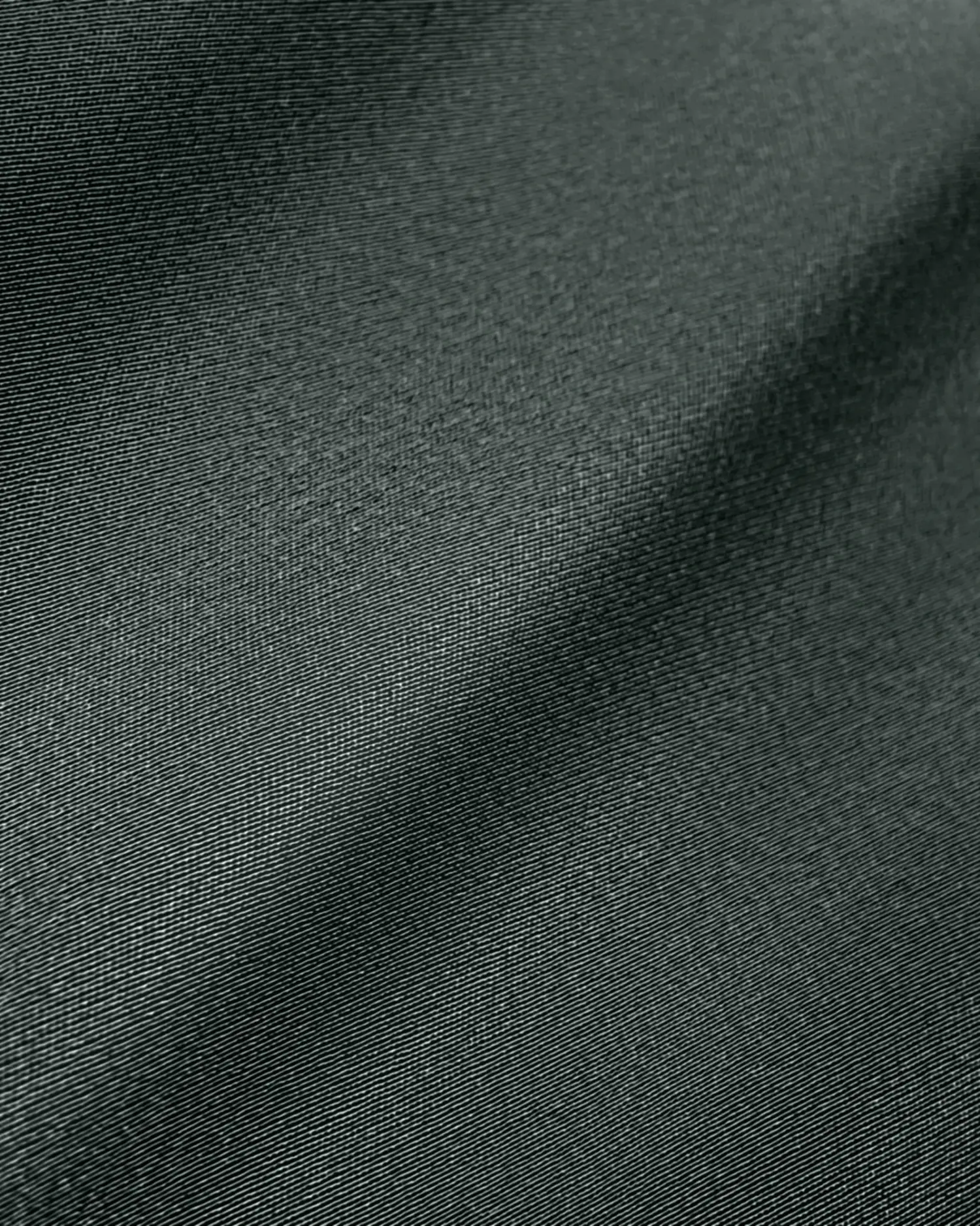 Close-up of smooth, dark grey fabric texture with subtle folds.
