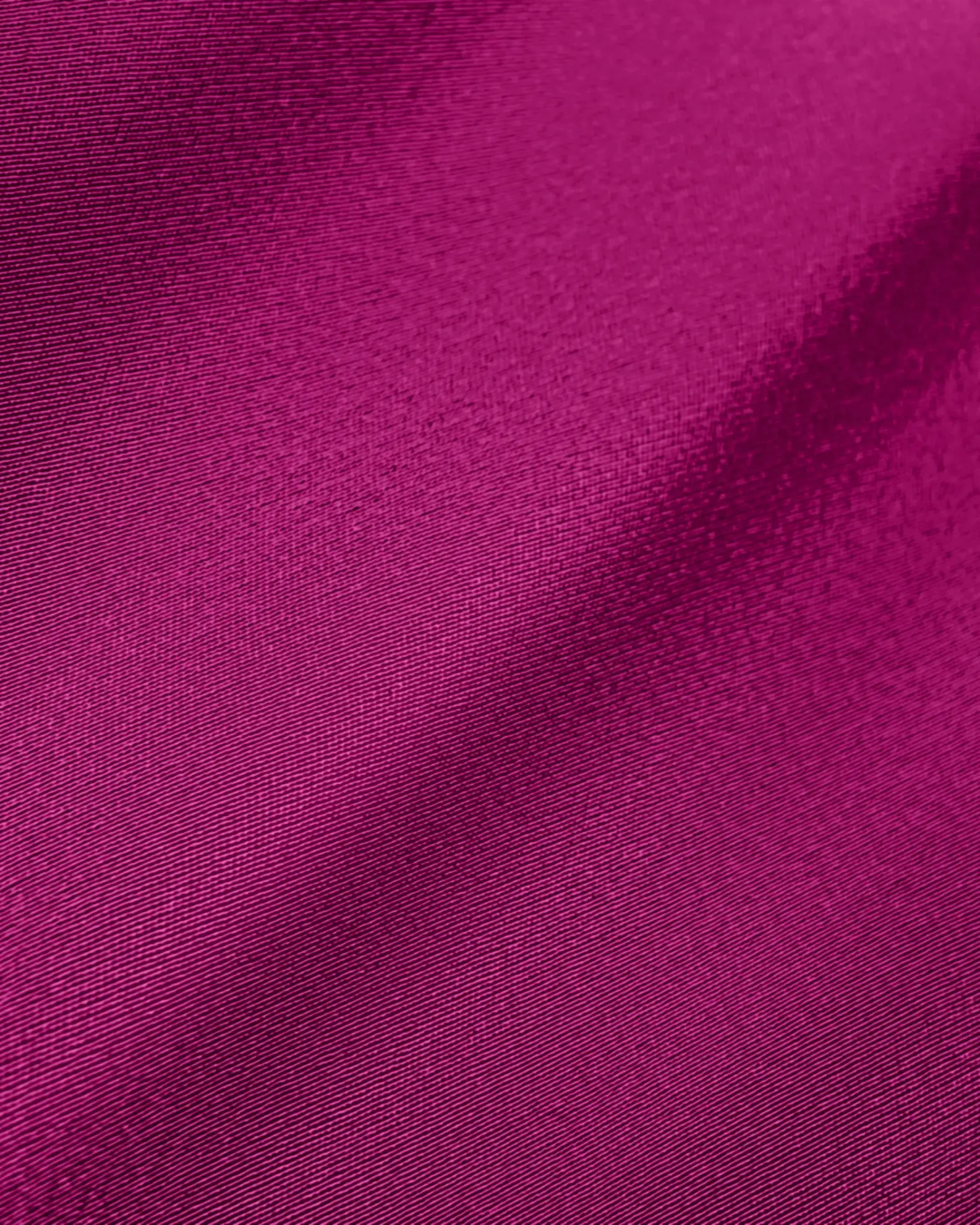 Close-up of magenta textile fabric showcasing smooth texture and vibrant color.