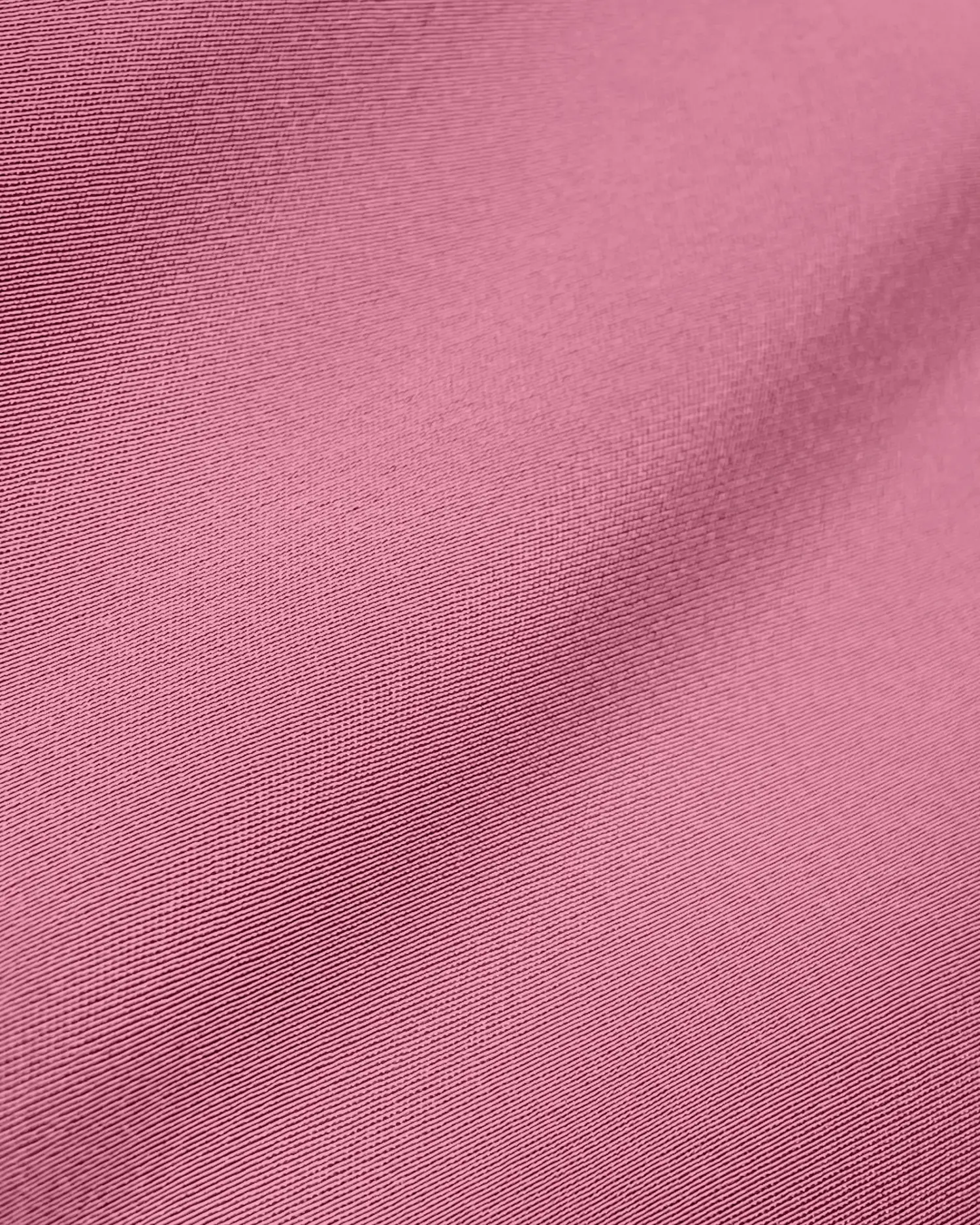 Close-up of pink fabric texture, showcasing fine weave and smooth surface, ideal for textiles or fashion design.