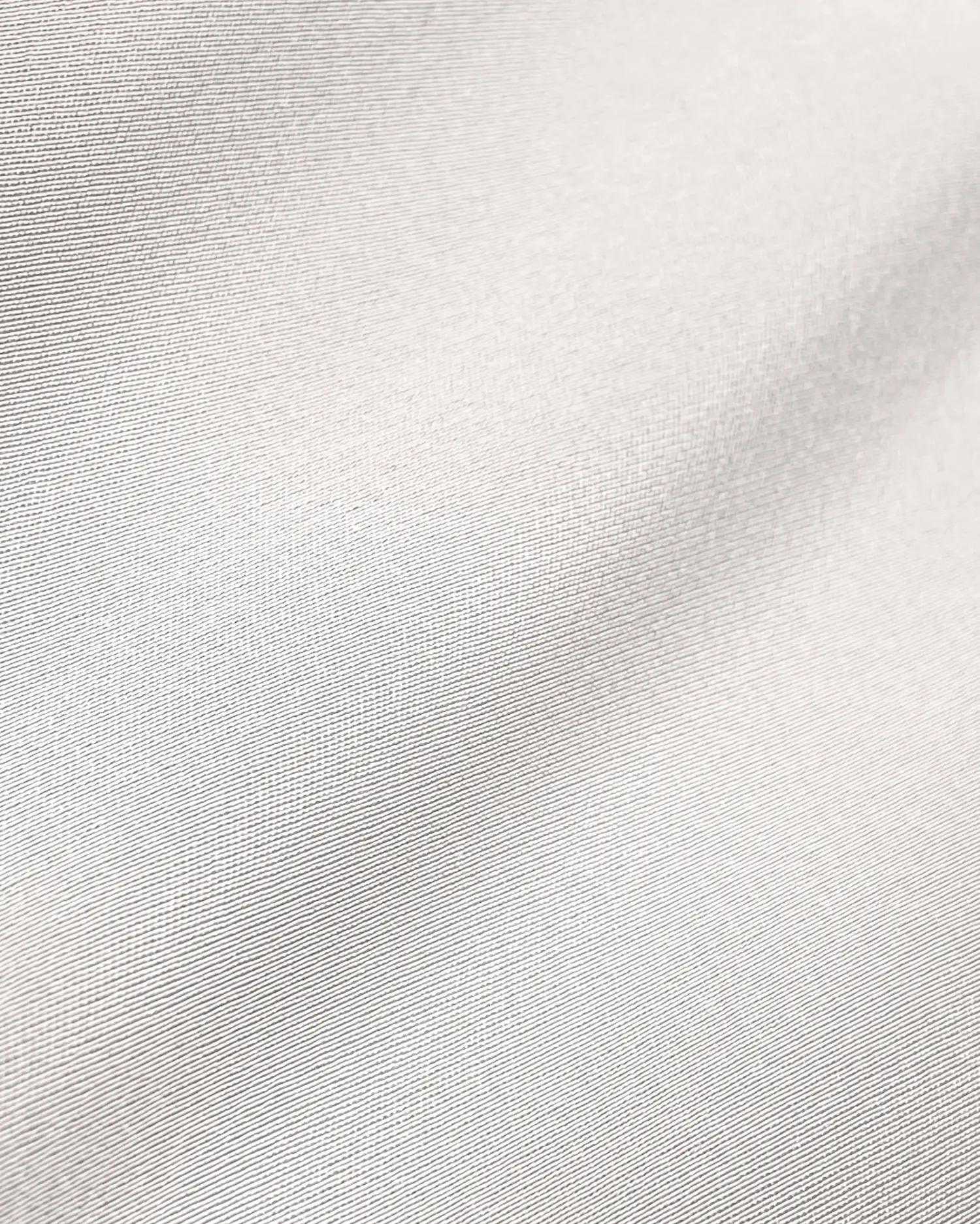 Close-up of smooth, white fabric texture highlighting fine weave and subtle sheen.
