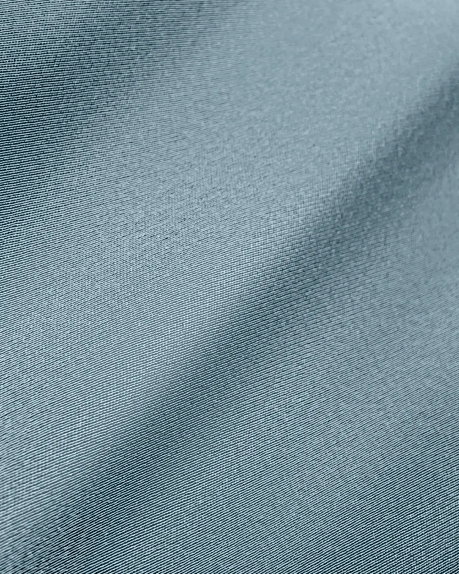 Close-up of smooth, textured blue fabric with subtle folds and lighting.