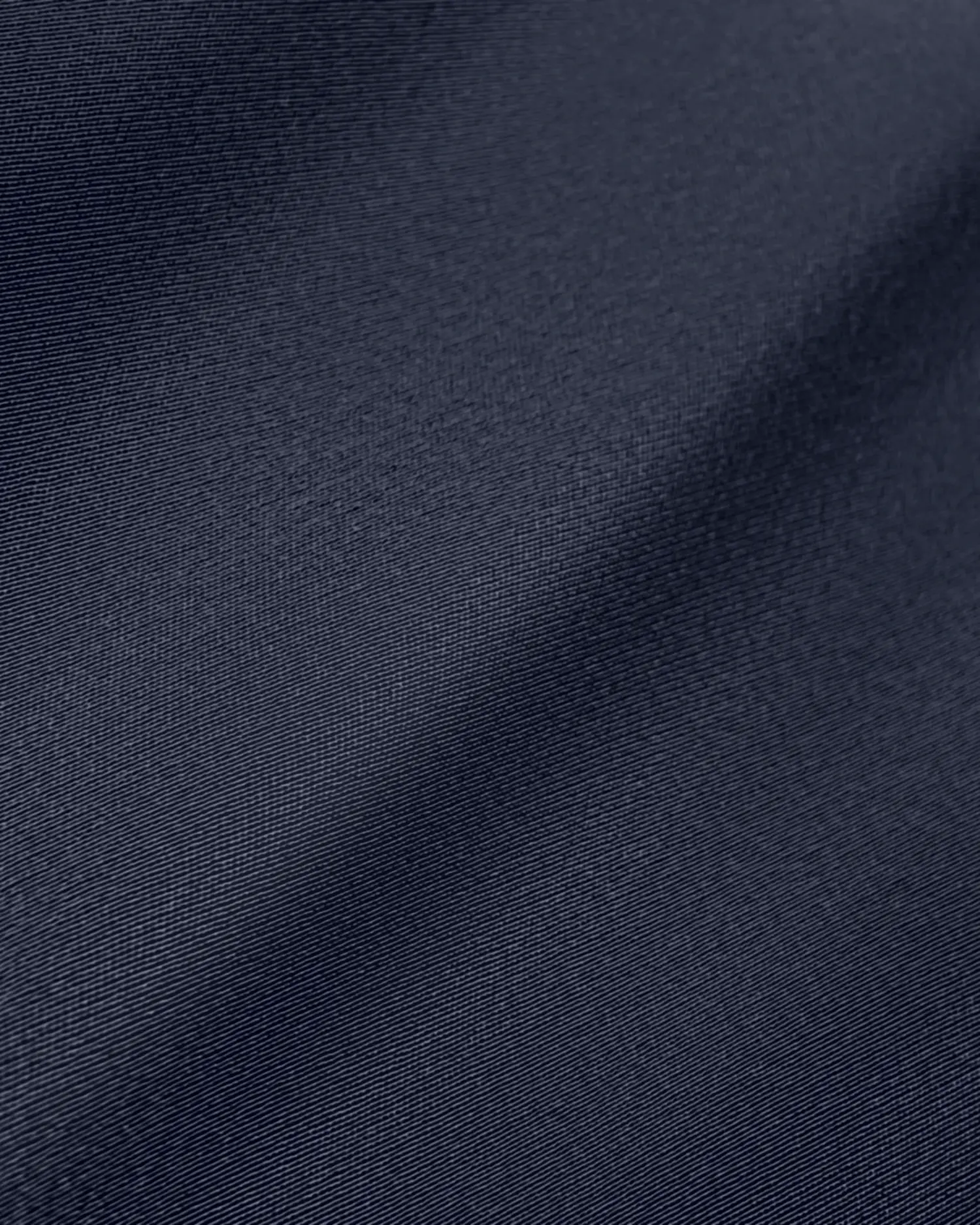 Close-up of smooth, dark fabric texture with gentle folds, perfect for design or textile background applications.