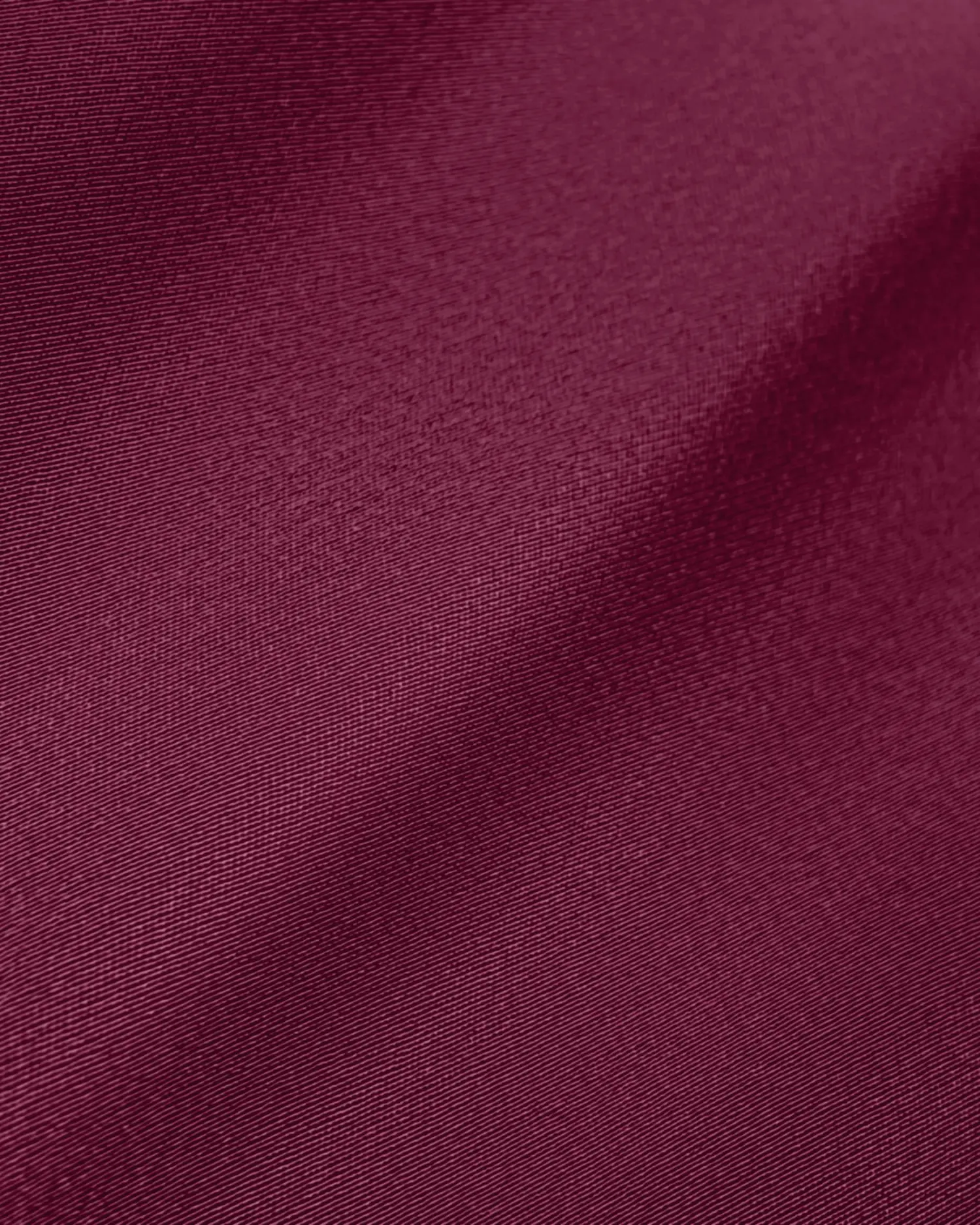 Close-up of smooth maroon fabric texture with subtle folds, ideal for textiles, design, and fashion backgrounds.