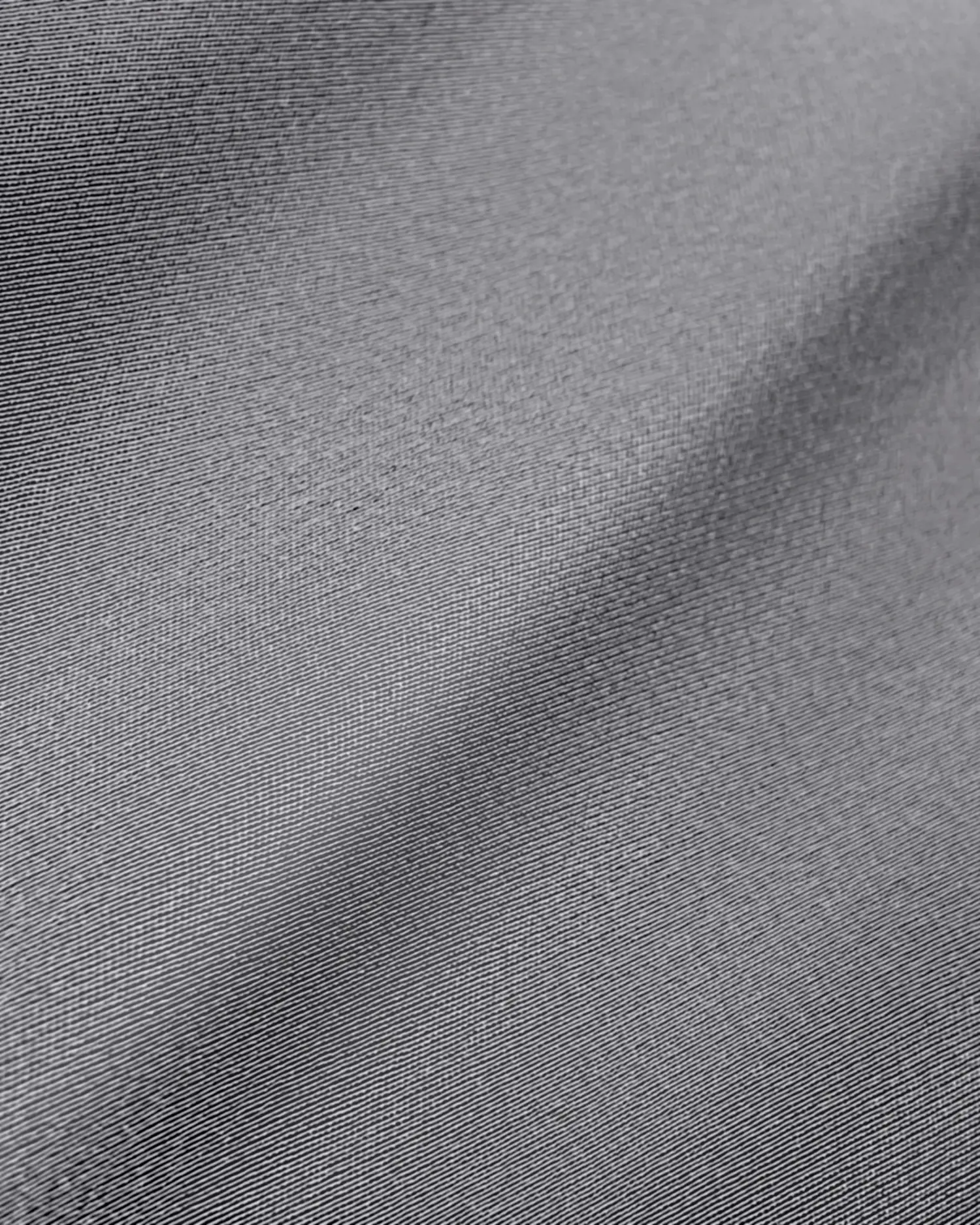 Close-up of smooth, gray silk fabric texture with a subtle sheen and gentle folds.