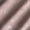 Pink fabric with intricate embossed peacock feather pattern, highlighted by soft natural light.