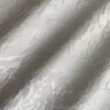 Elegant white jacquard fabric with intricate swirling pattern, capturing light and texture for a luxurious appearance.