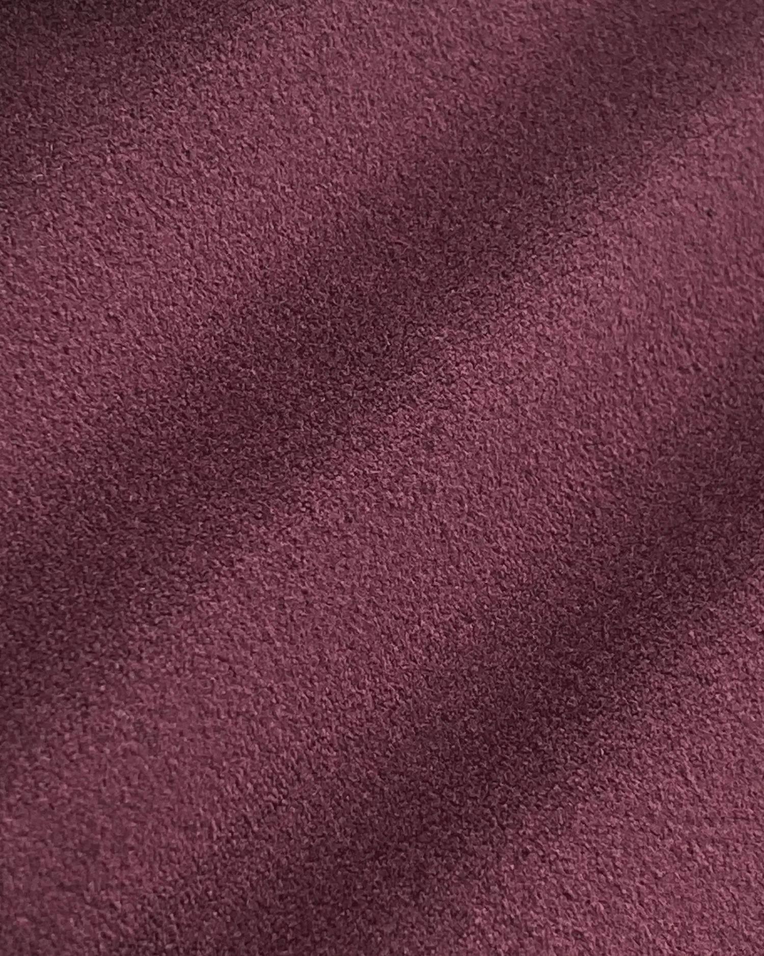 Close-up of soft purple velvet texture with subtle shadows, showcasing its rich, plush surface. Perfect for luxury fabric themes.