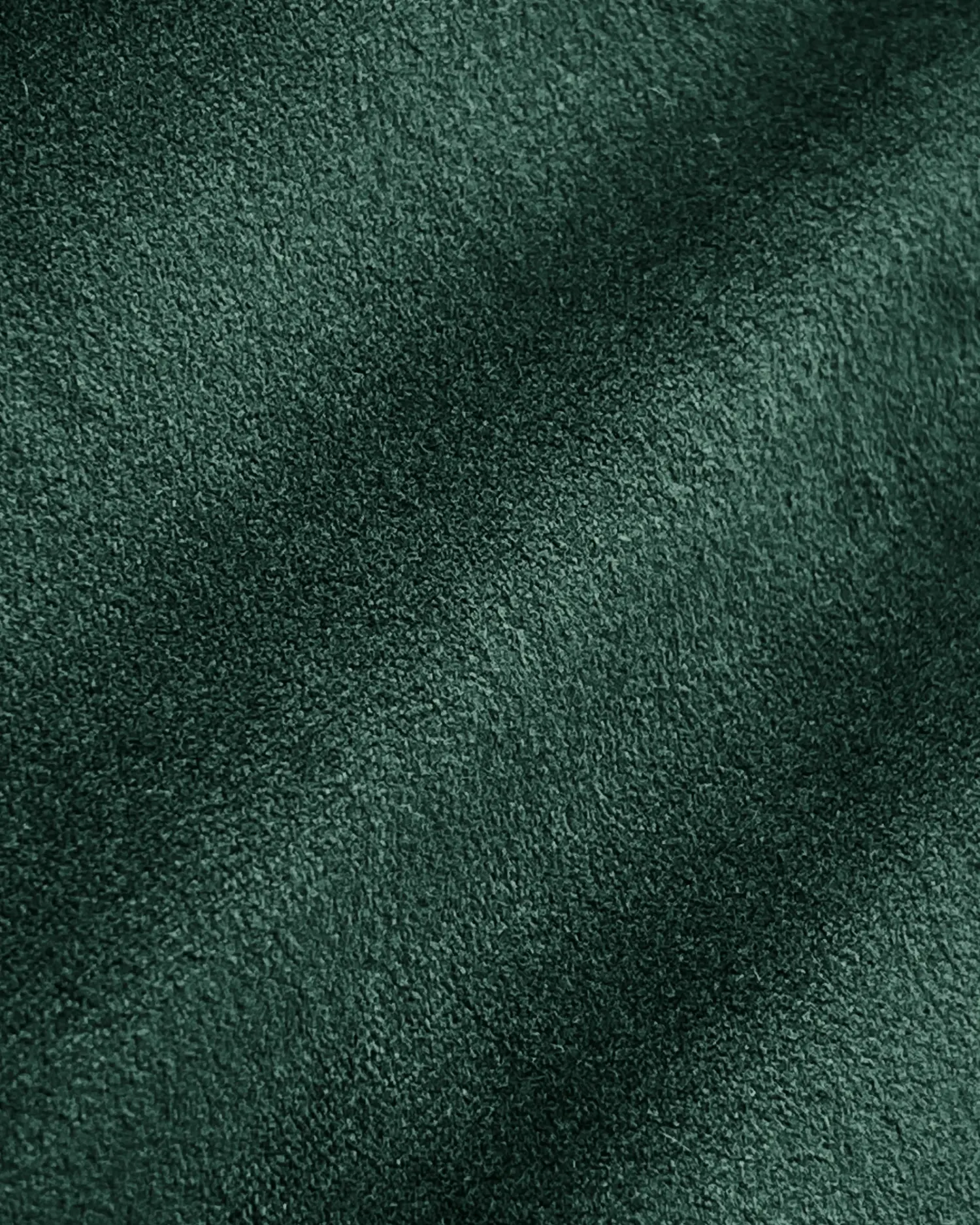 Close-up of soft, textured green suede fabric, ideal for upholstery and fashion design projects.