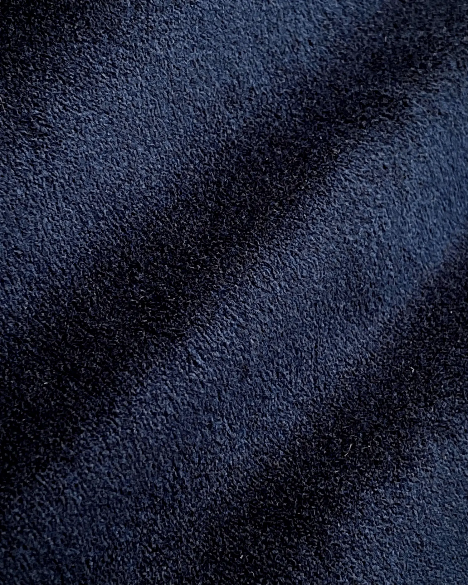 Close-up of dark blue textured fabric with light and shadow variations.