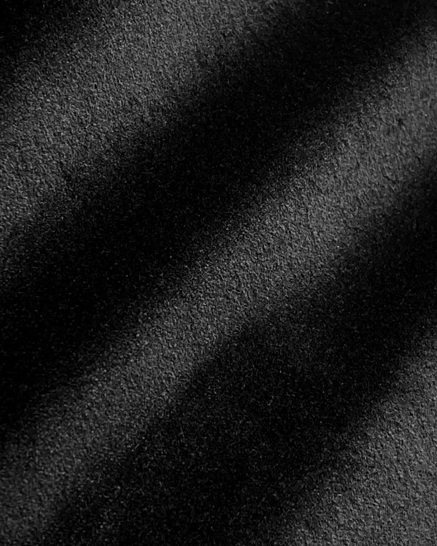 Black textured fabric with subtle diagonal shadows, creating a sleek and refined appearance.