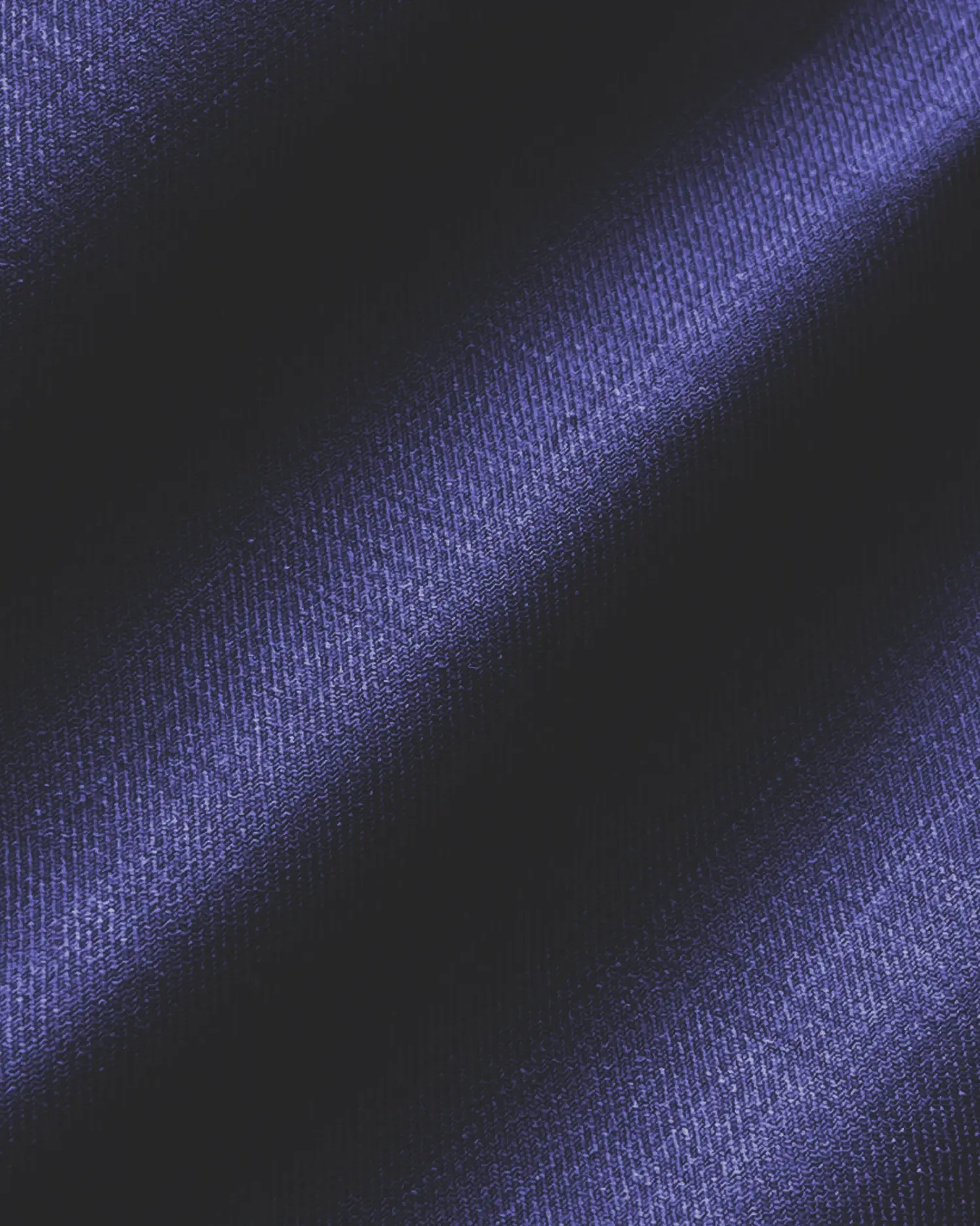 Close-up of dark blue textured fabric with diagonal light and shadow patterns.