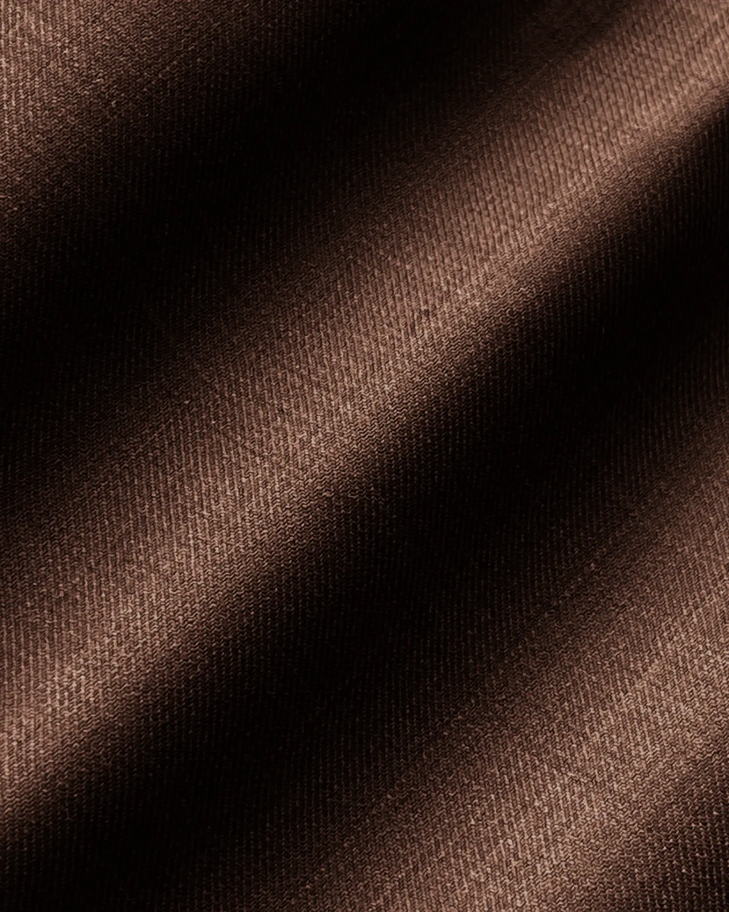 Brown fabric texture with soft, diagonal light and shadow, showcasing rich material details and wave patterns.
