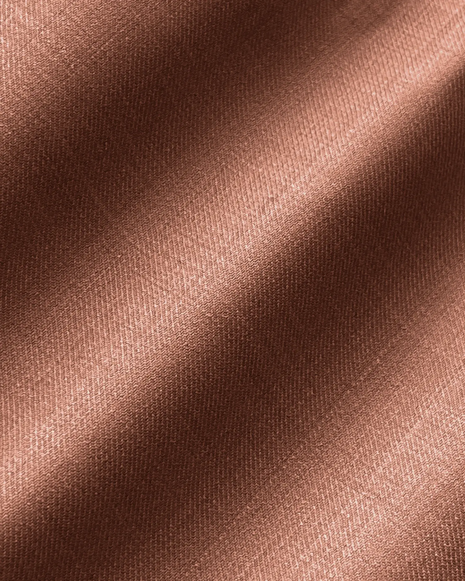 Close-up of textured brown fabric with subtle diagonal lighting.