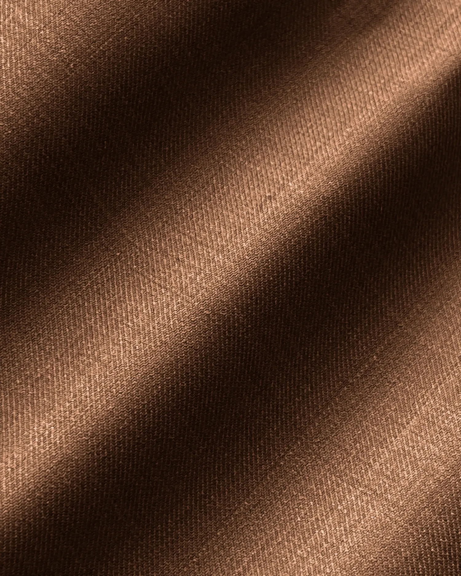 Close-up of brown textured fabric with diagonal shadow lines, creating a soft and elegant appearance.