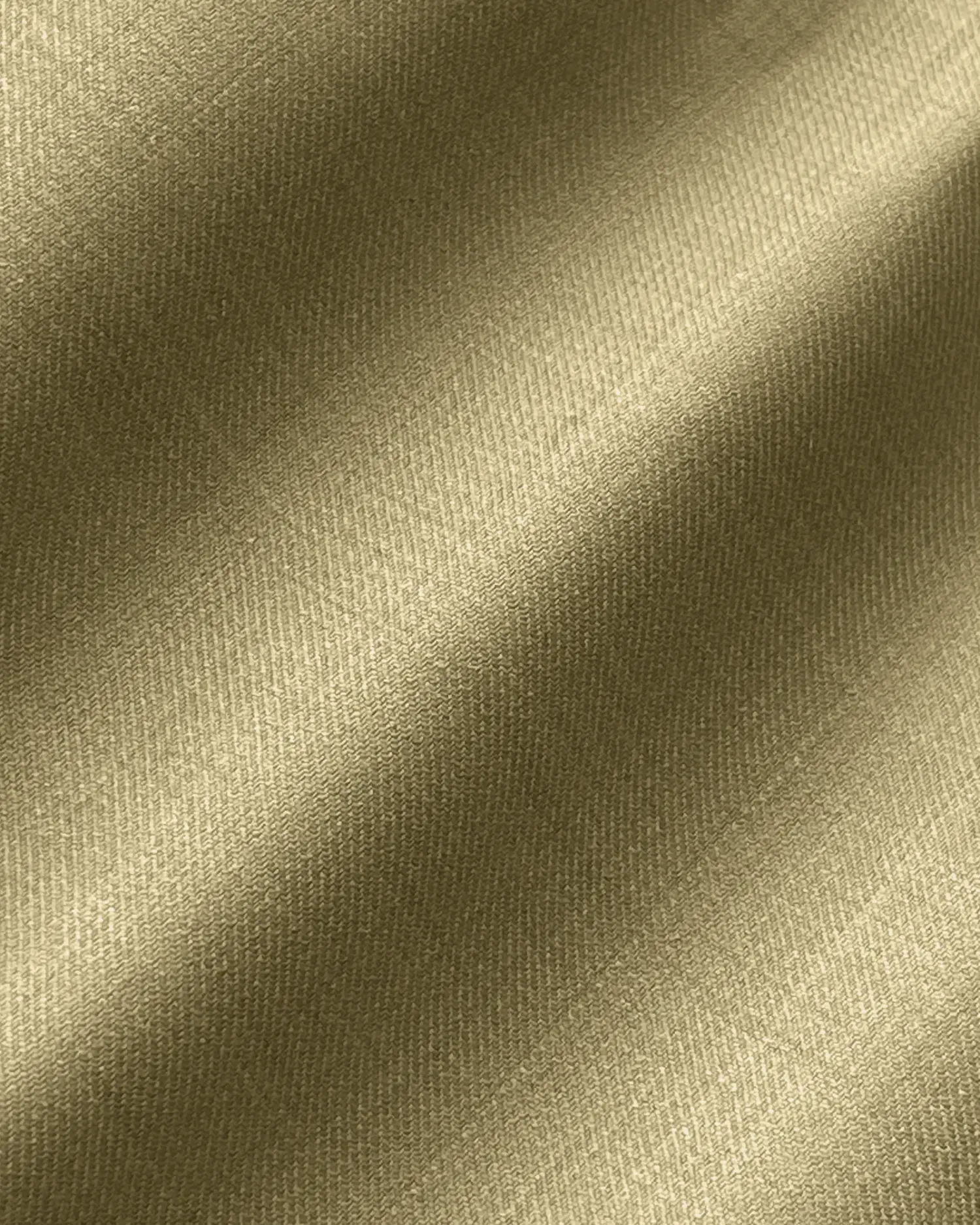 Close-up of smooth, gold silk fabric with a subtle diagonal weave pattern, highlighting its luxurious texture and sheen.