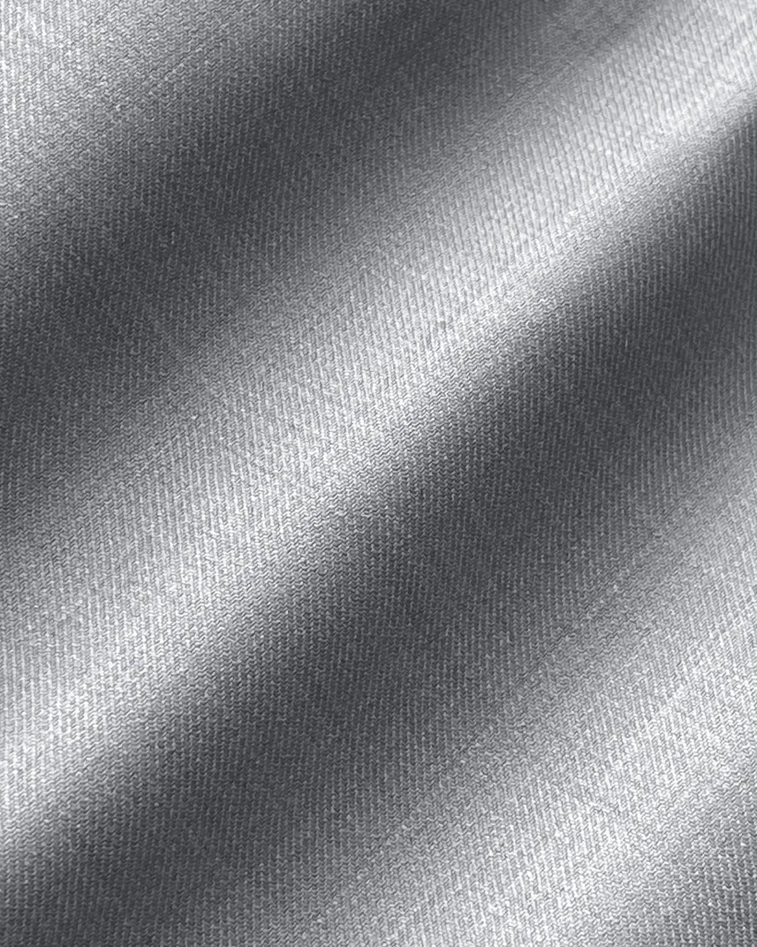 Close-up of smooth silver satin fabric with a shiny, textured surface.
