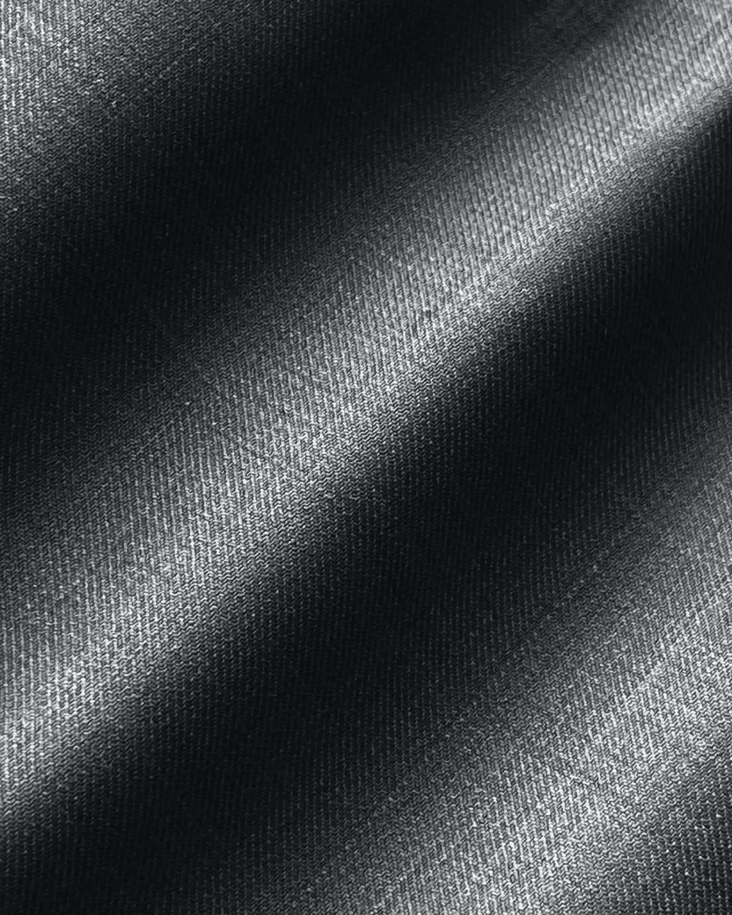 Black woven fabric with diagonal light and shadow pattern, showing textured detail.