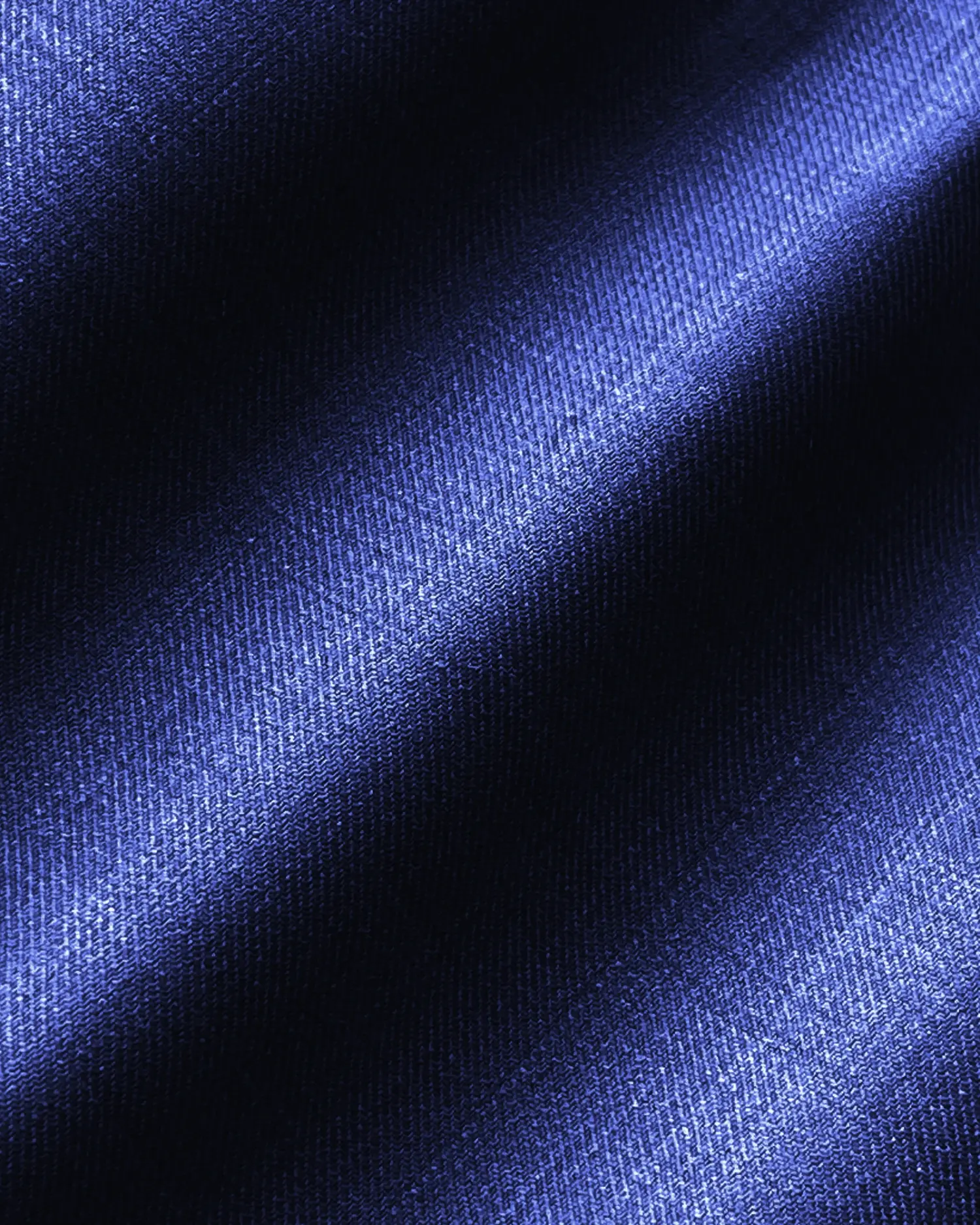 Close-up of textured blue fabric with diagonal light and shadow pattern.