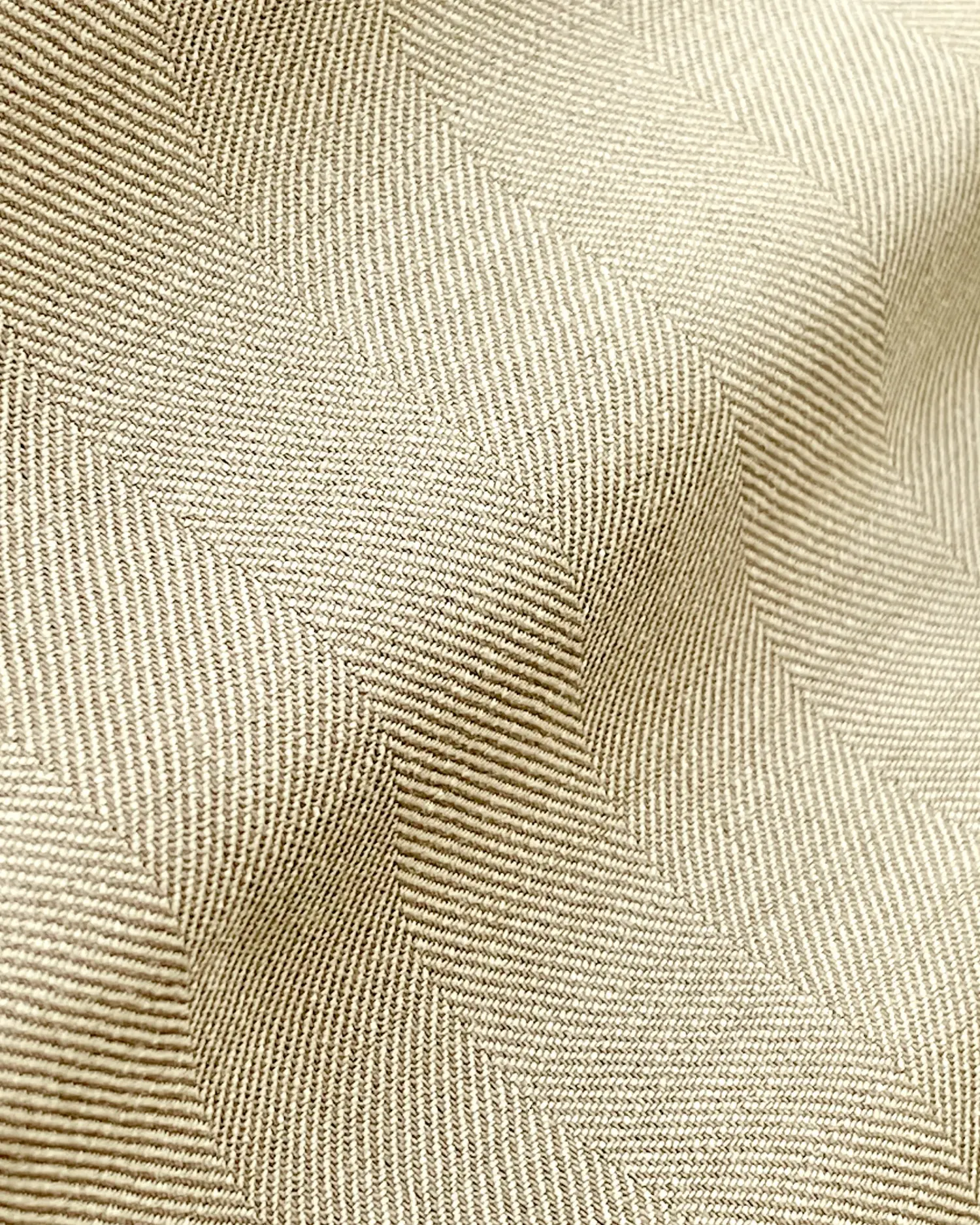 Close-up of beige fabric with a detailed herringbone pattern, showcasing texture and weave.