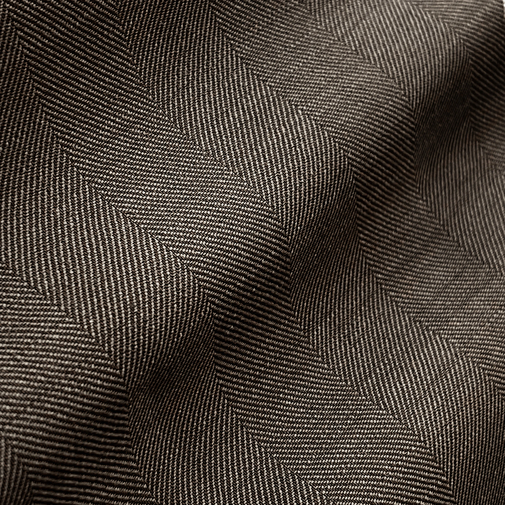 Close-up of textured herringbone fabric with wavy folds, showcasing intricate weave patterns and depth.