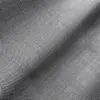 Close-up of gray herringbone fabric texture with wavy folds, showcasing detailed pattern and texture.