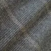 Close-up of a textured gray and brown fabric with a subtle plaid pattern, perfect for cozy textiles and stylish decor.