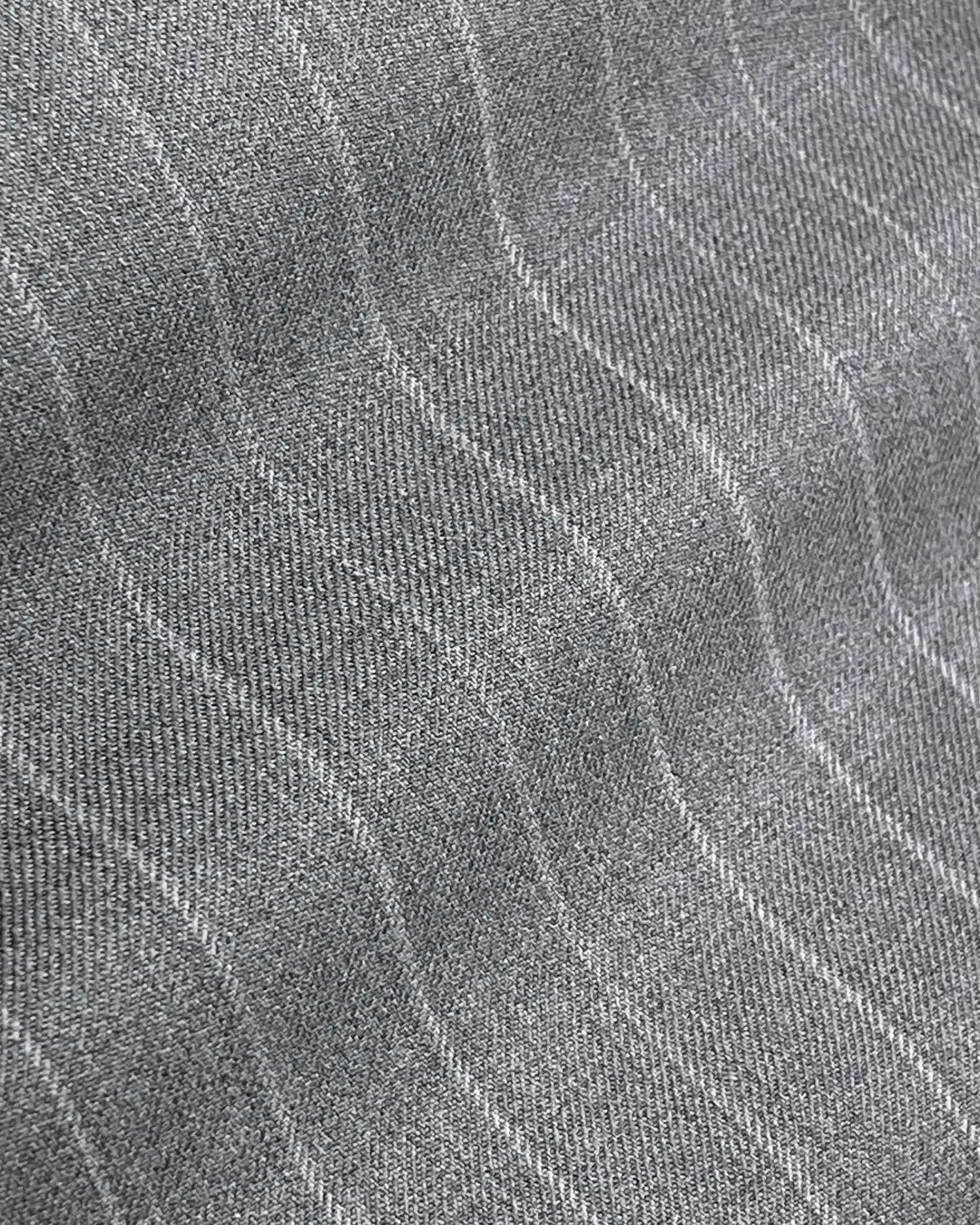 Close-up of gray fabric with subtle wavy stripes, showcasing texture and pattern, ideal for fashion or home decor.