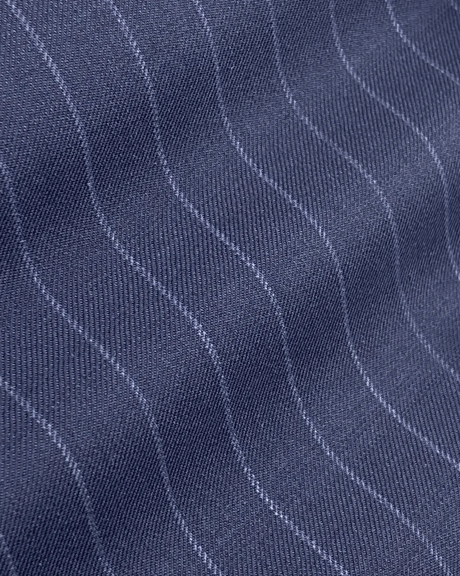 Close-up of dark blue wavy pinstripe fabric with light grey lines, showcasing texture and pattern.