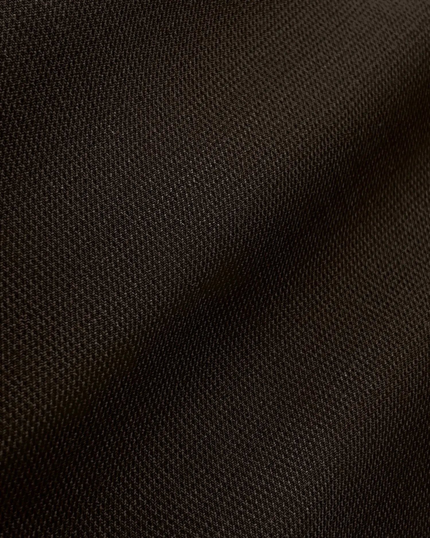 Close-up of dark brown textured fabric with visible weave patterns.