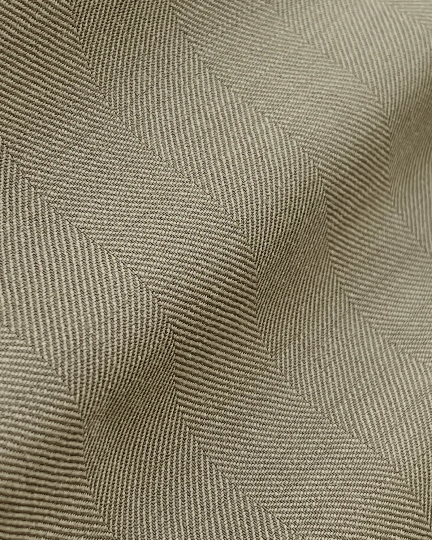 Close-up of beige herringbone textured fabric with wavy pattern showcasing intricate weaving detail.