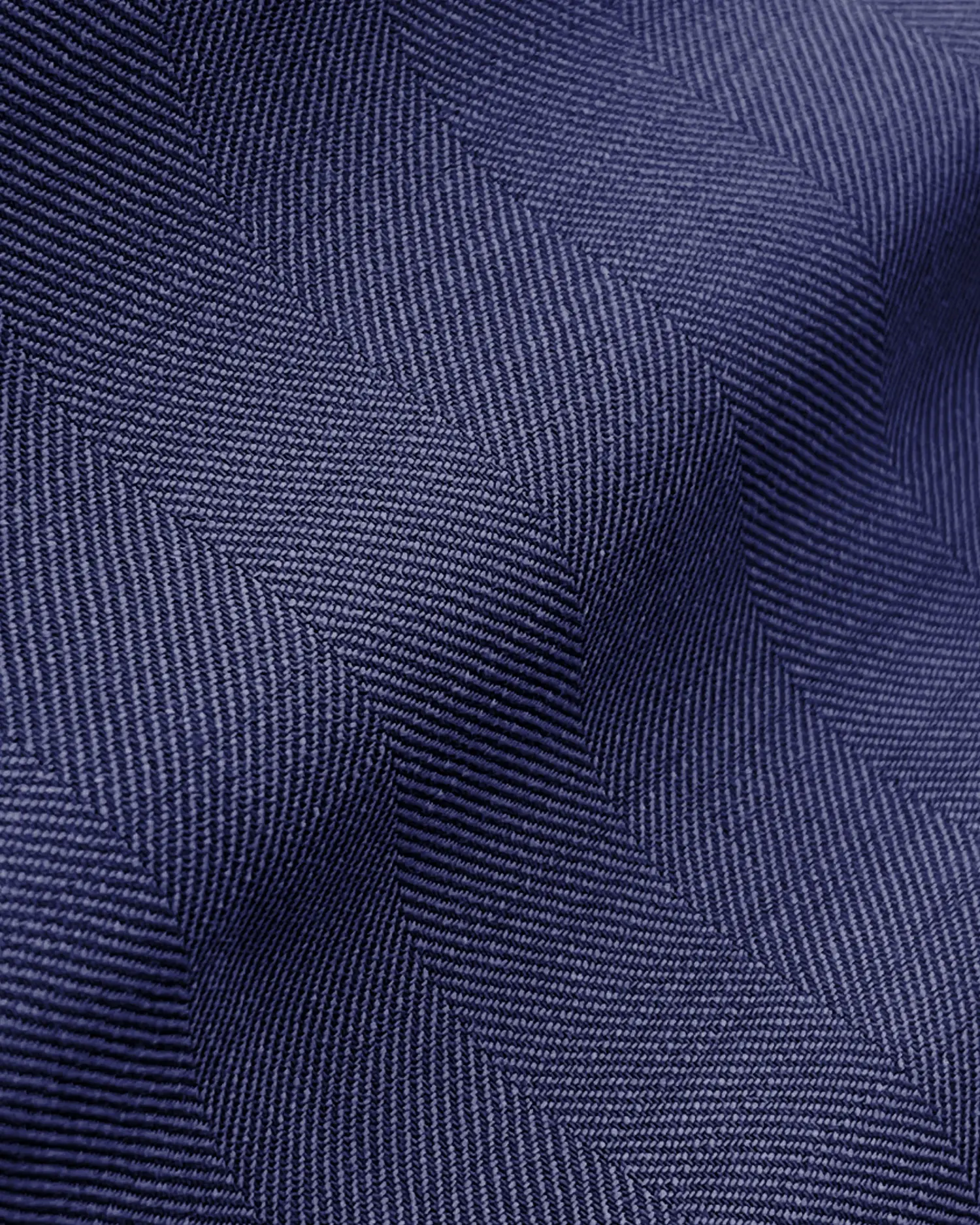Close-up of blue herringbone fabric texture, showcasing detailed woven pattern and texture.