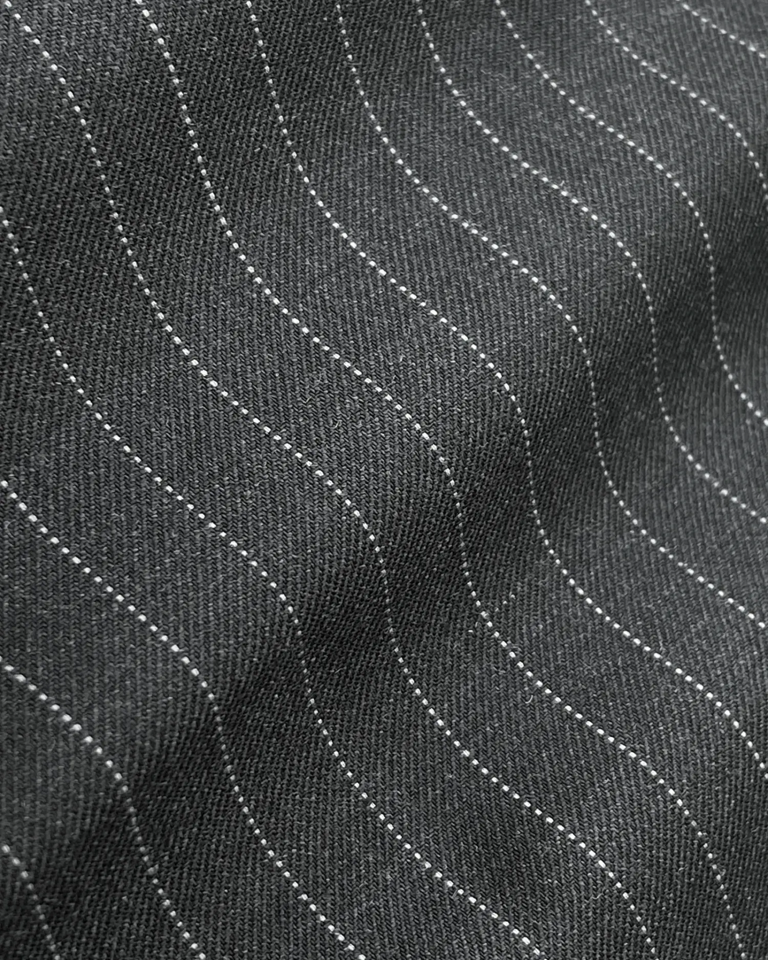Wavy gray fabric with dotted lines creating a textured pattern.