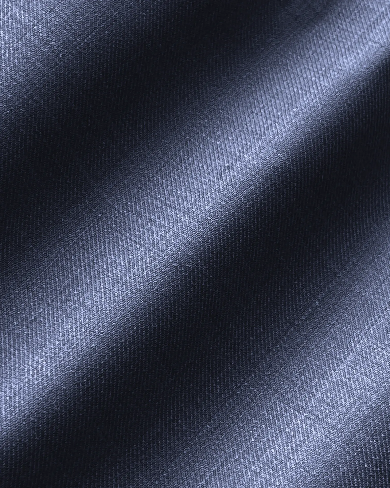 Close-up of textured blue fabric, showcasing a soft, diagonal weave with light and shadow effects.