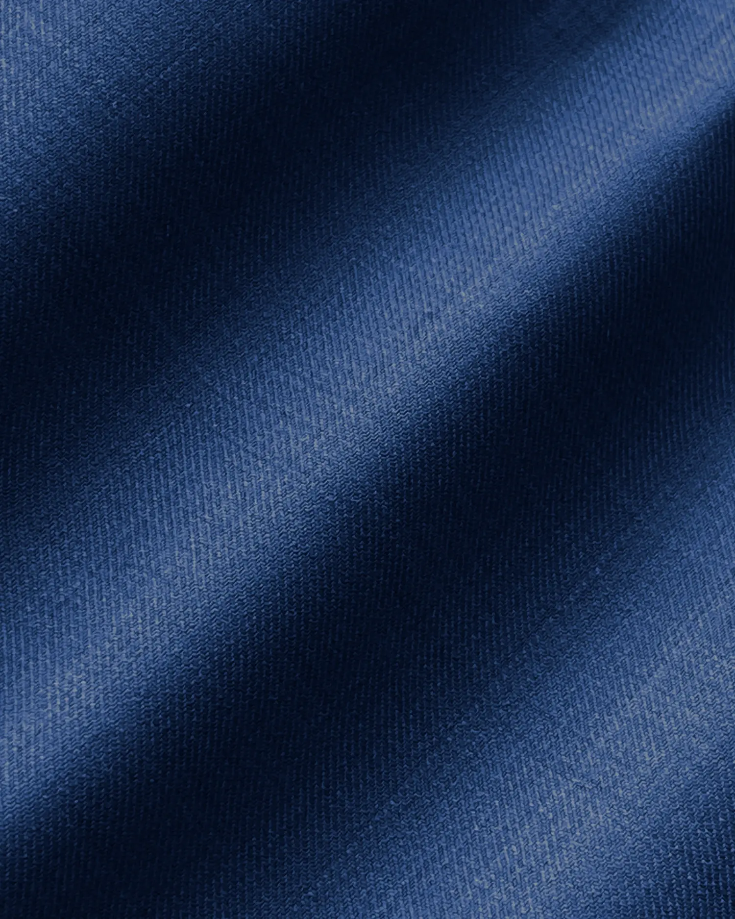 Close-up of textured blue denim fabric with soft shadows.