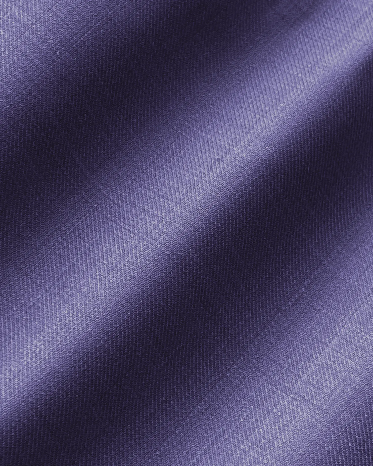 Purple fabric texture with diagonal lighting, showcasing smooth and rich textile details. Perfect for fashion or design elements.