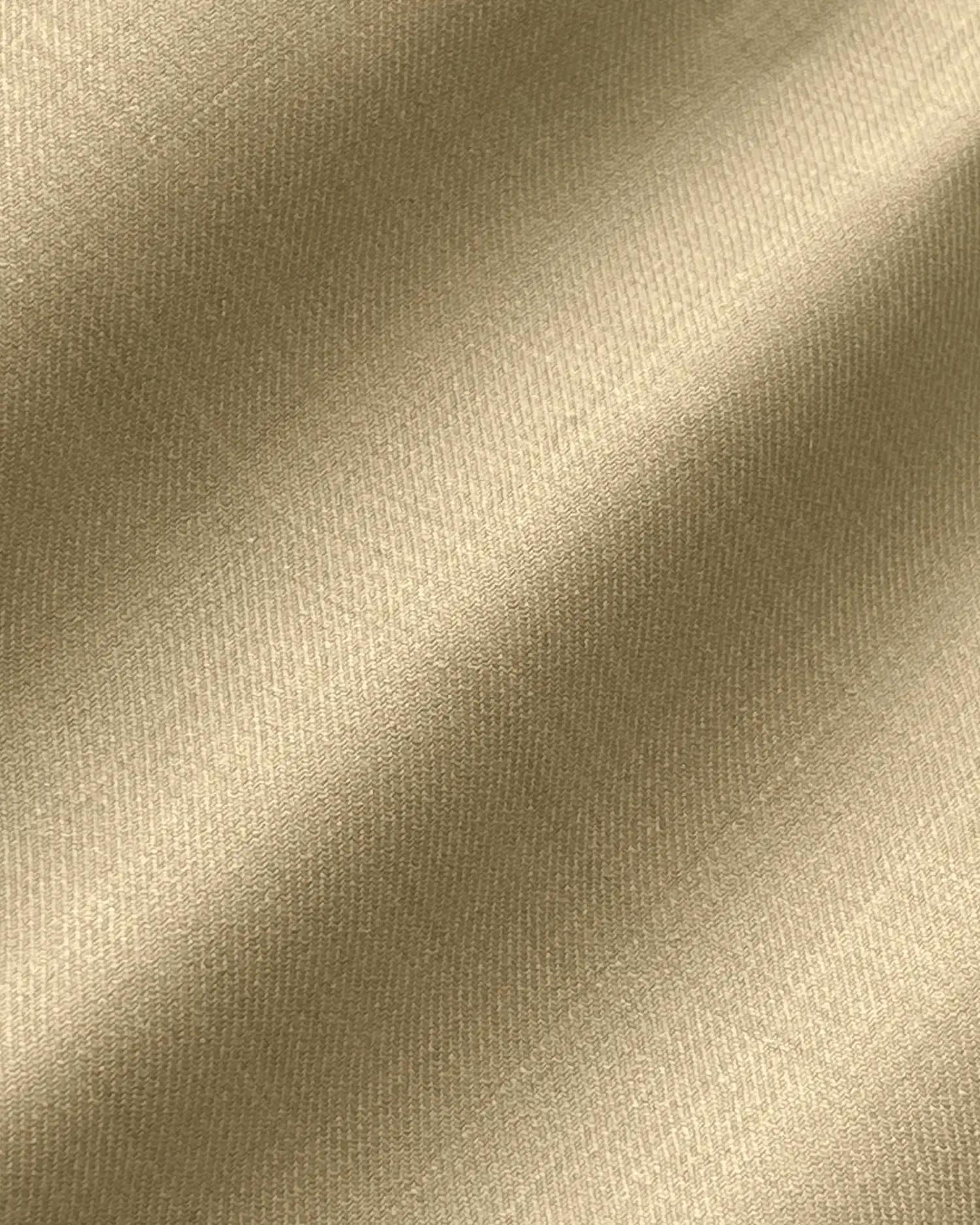 Close-up of smooth beige satin fabric texture with gentle folds.