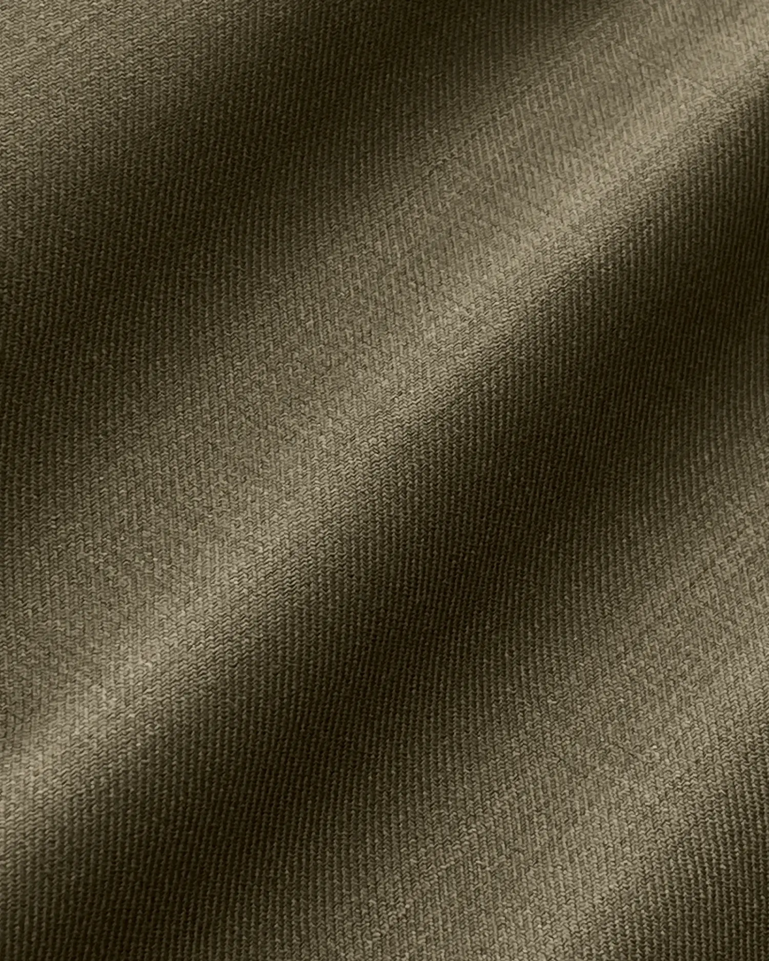 Close-up of textured olive green fabric with diagonal patterns and a smooth surface.