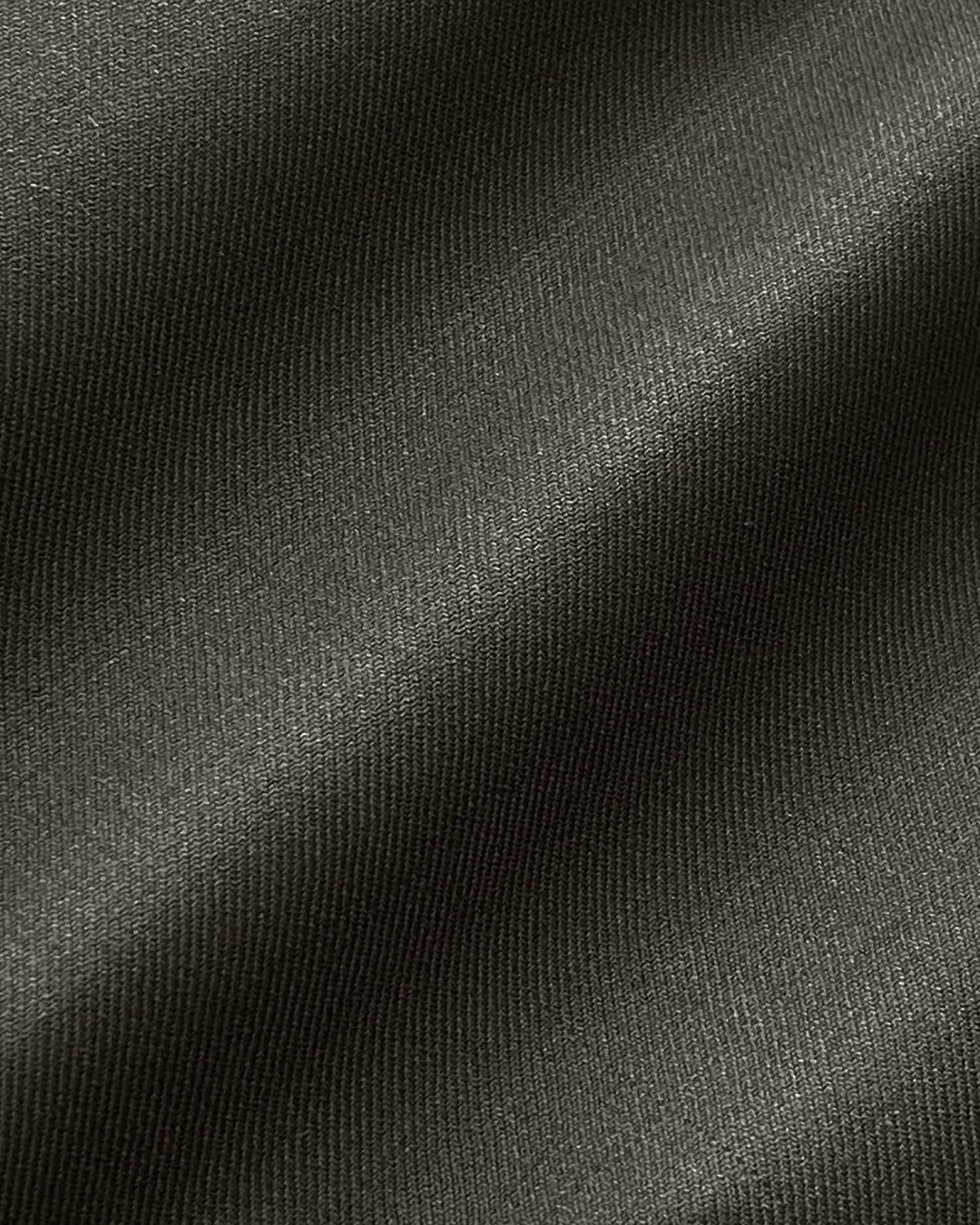 Close-up of smooth black fabric texture with subtle diagonal folds and shine.