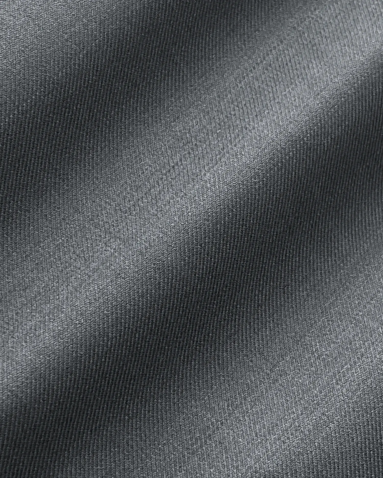 Close-up of dark grey fabric texture with diagonal folds and shadows.