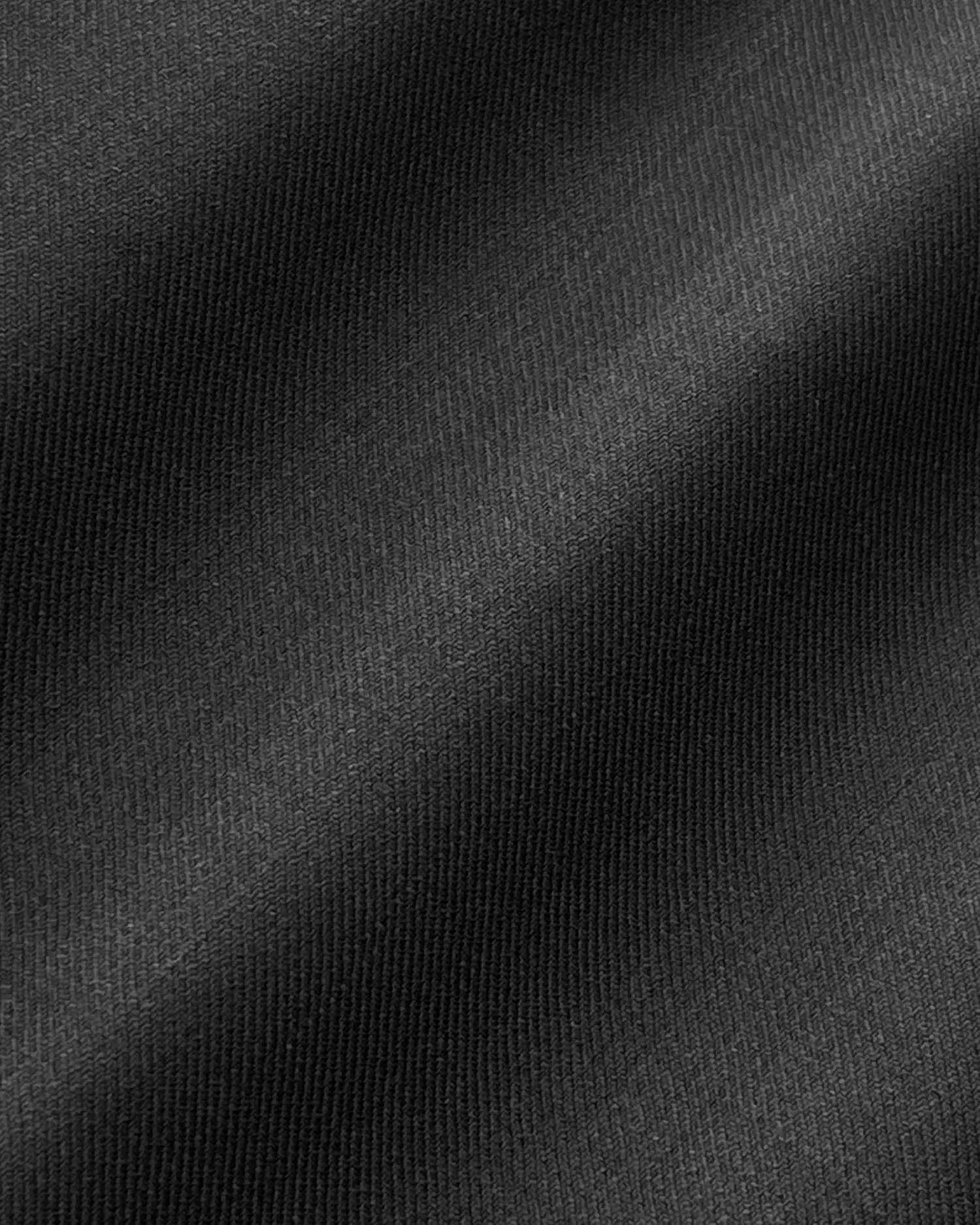 Close-up of smooth black fabric texture with soft shadows.