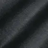 Close-up of textured black fabric with subtle diagonal lines and soft lighting.