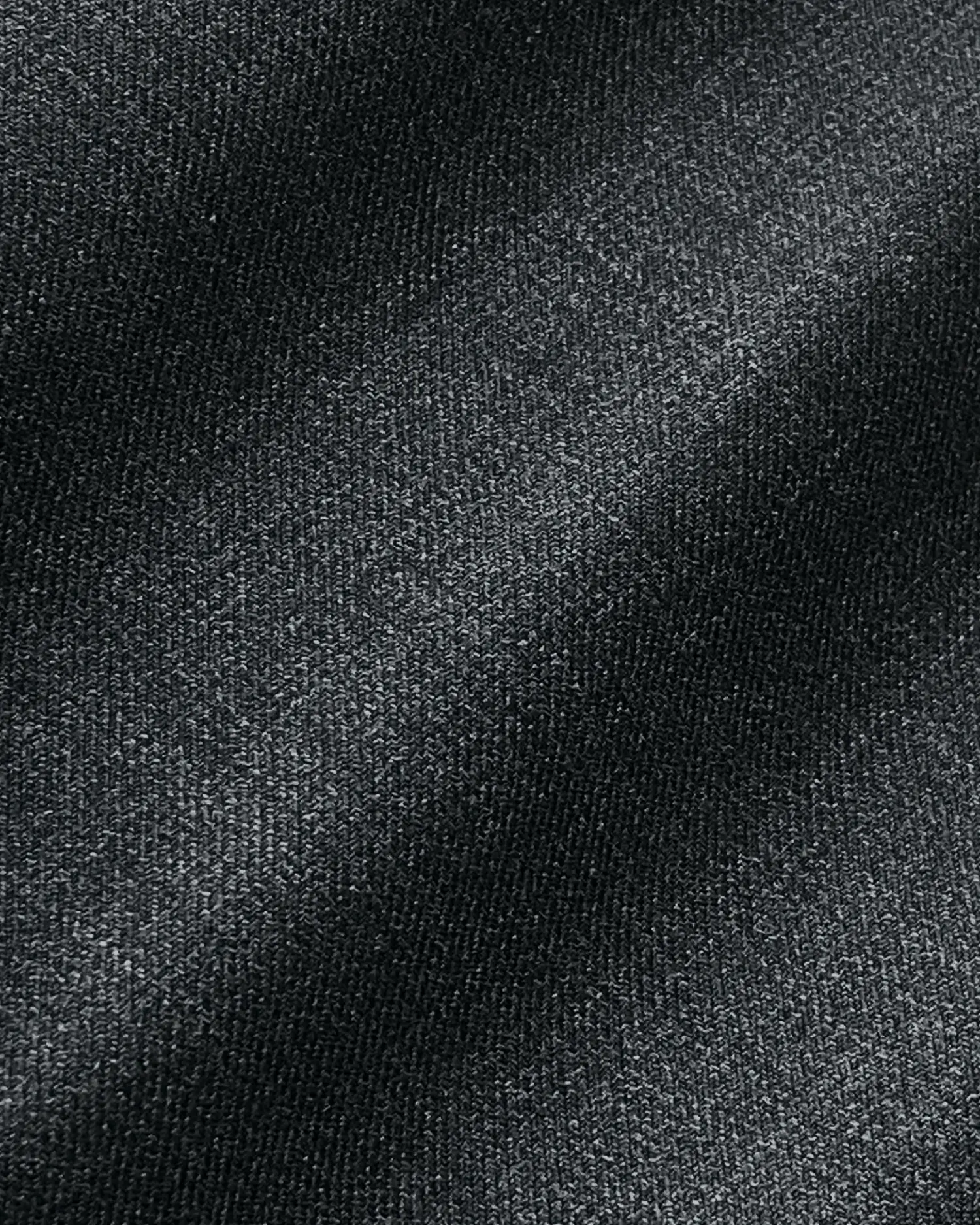 Close-up of textured black fabric with subtle diagonal lines and soft lighting.