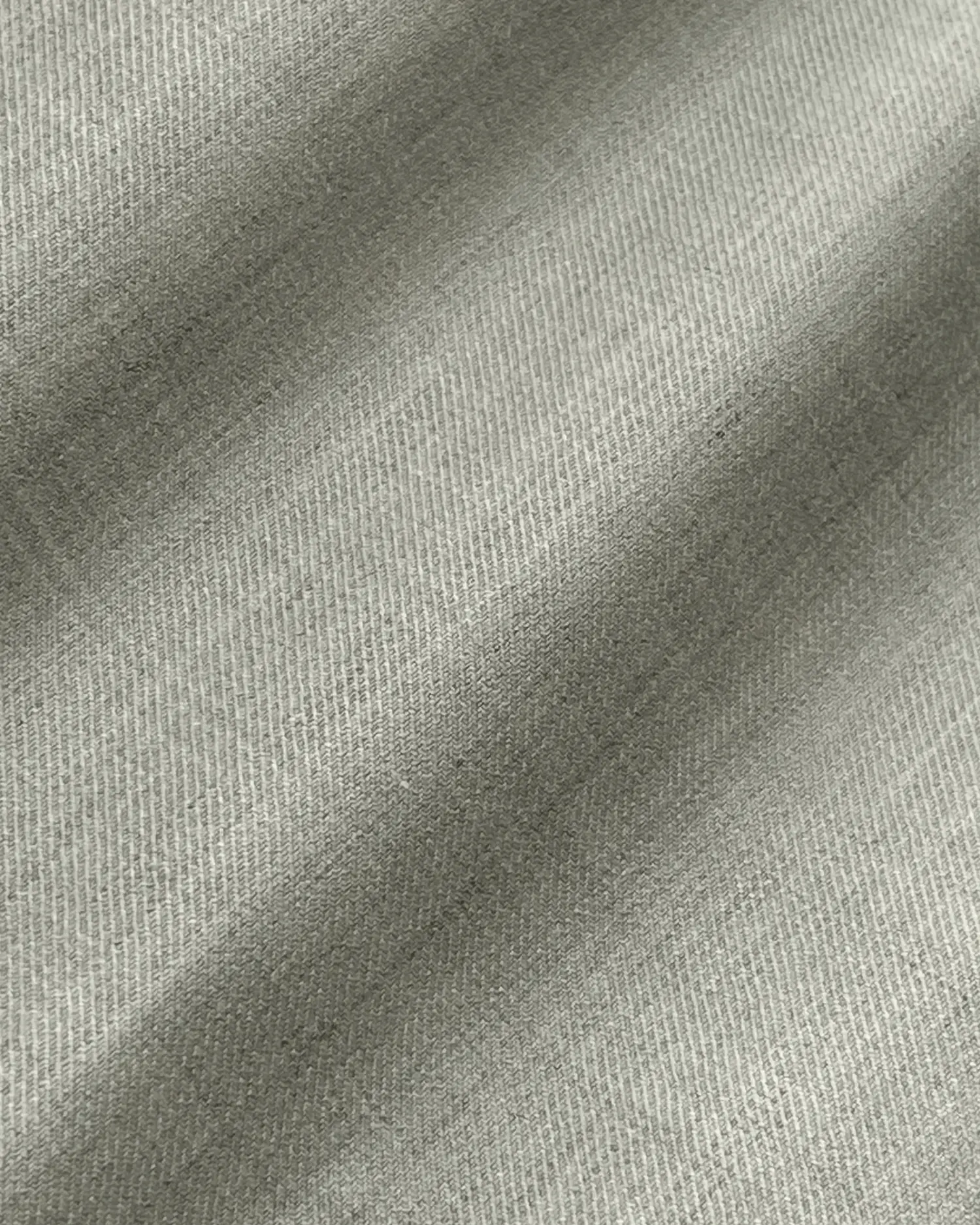 Close-up of textured grey fabric with gentle folds, showcasing fine weave pattern.