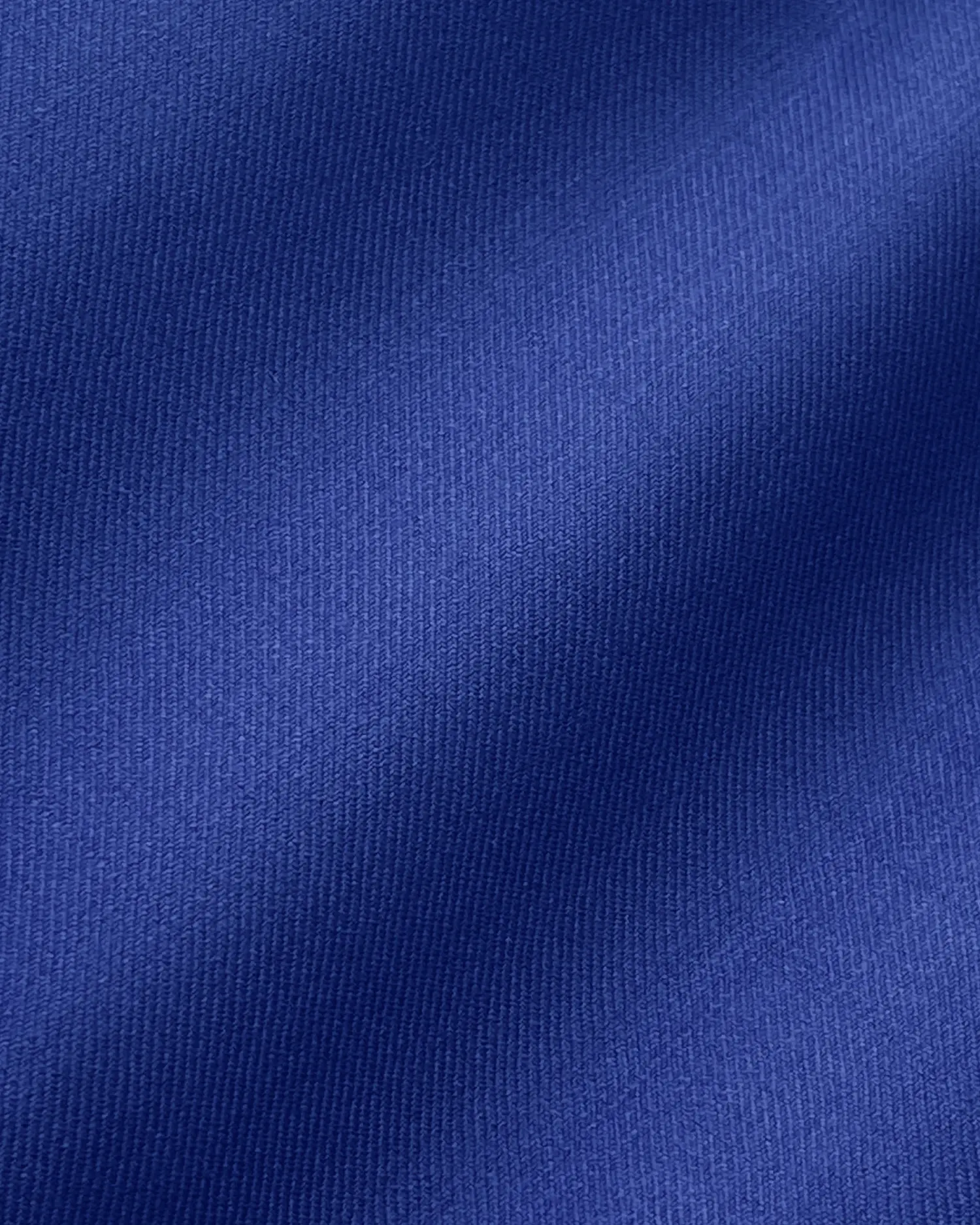 Close-up of smooth blue fabric with a textured surface, ideal for clothing design and material inspiration.