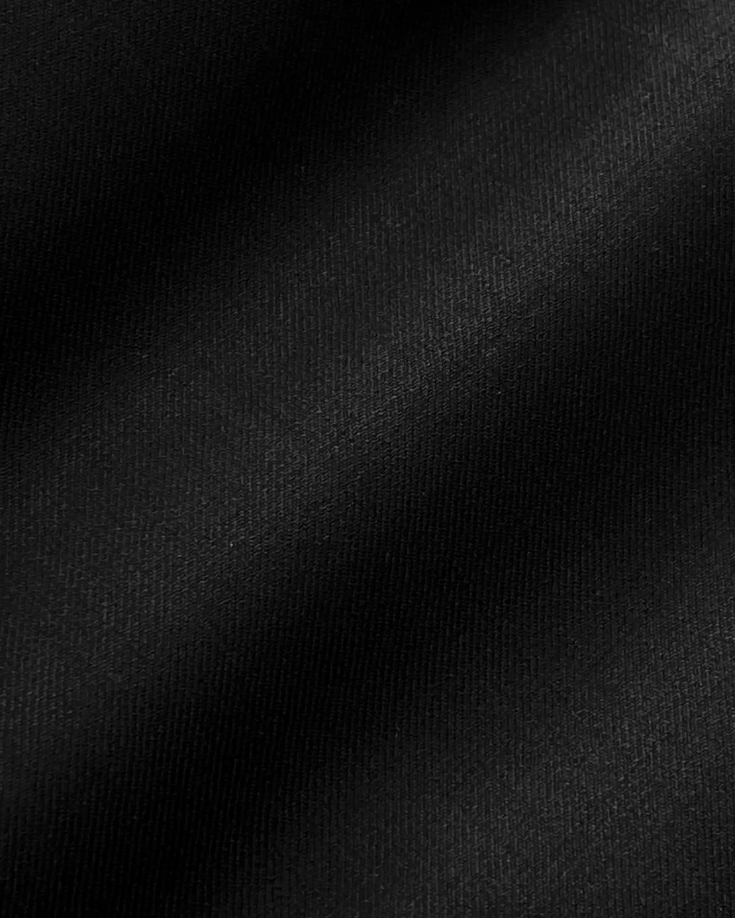 Close-up of black fabric texture with soft lighting. Perfect for backgrounds, textiles, or fashion design concepts.