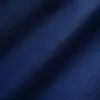 Close-up of dark blue textured fabric with a subtle floral pattern, ideal for upscale fashion or upholstery applications.