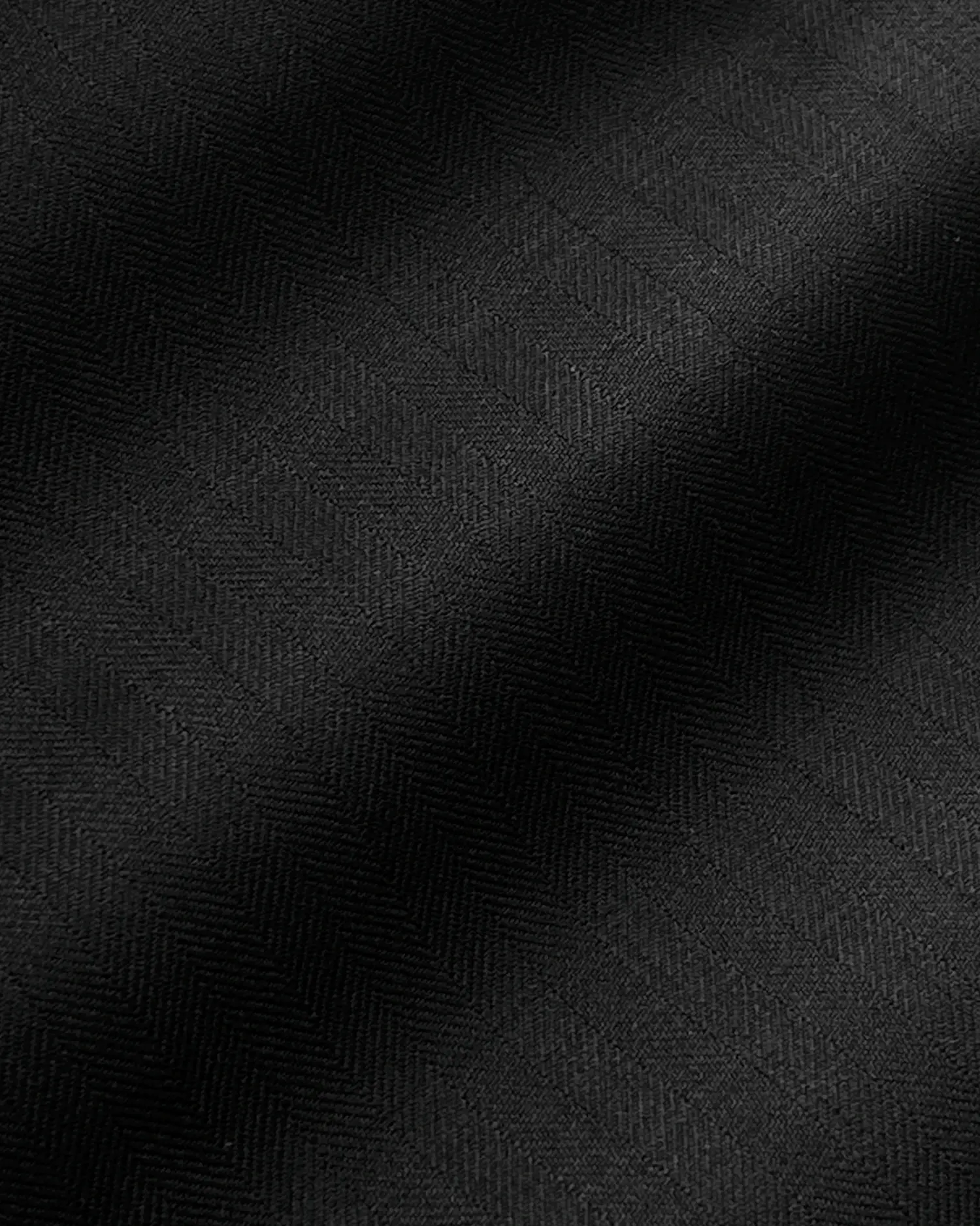 Black fabric with subtle chevron pattern, smooth texture, perfect for elegant apparel and interior design concepts.